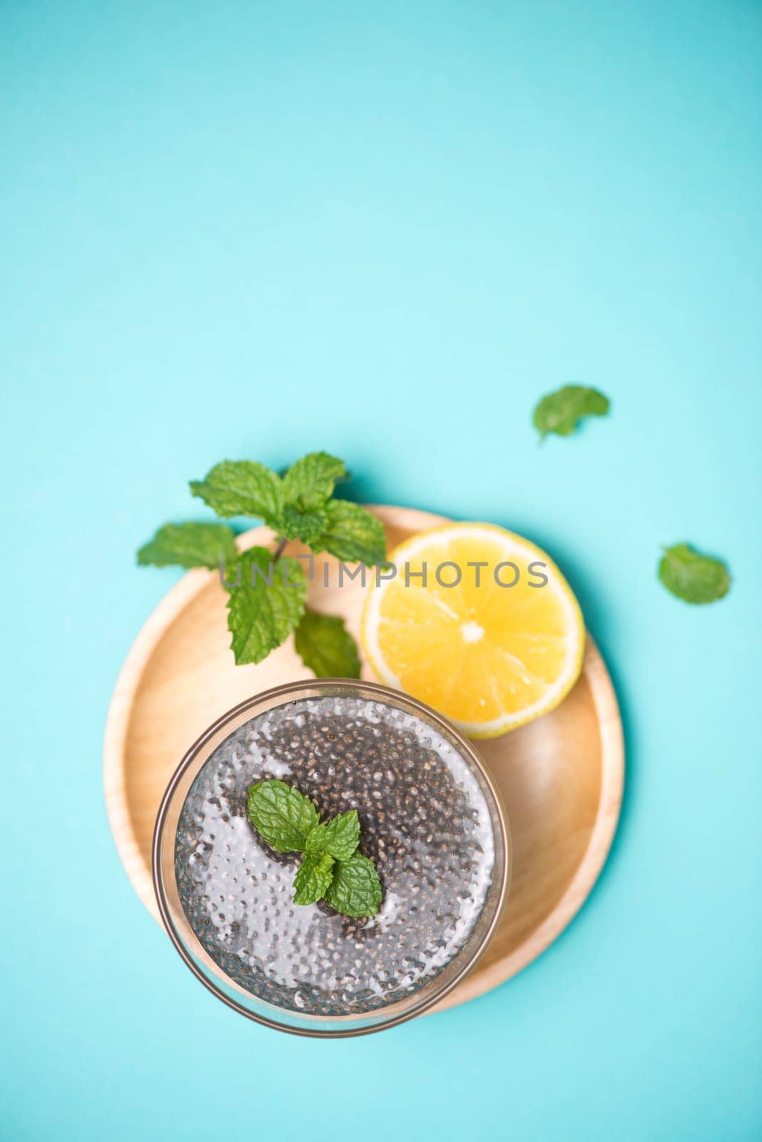 Selective focus of chia seeds drink with water in transparent glass with lemon balm.