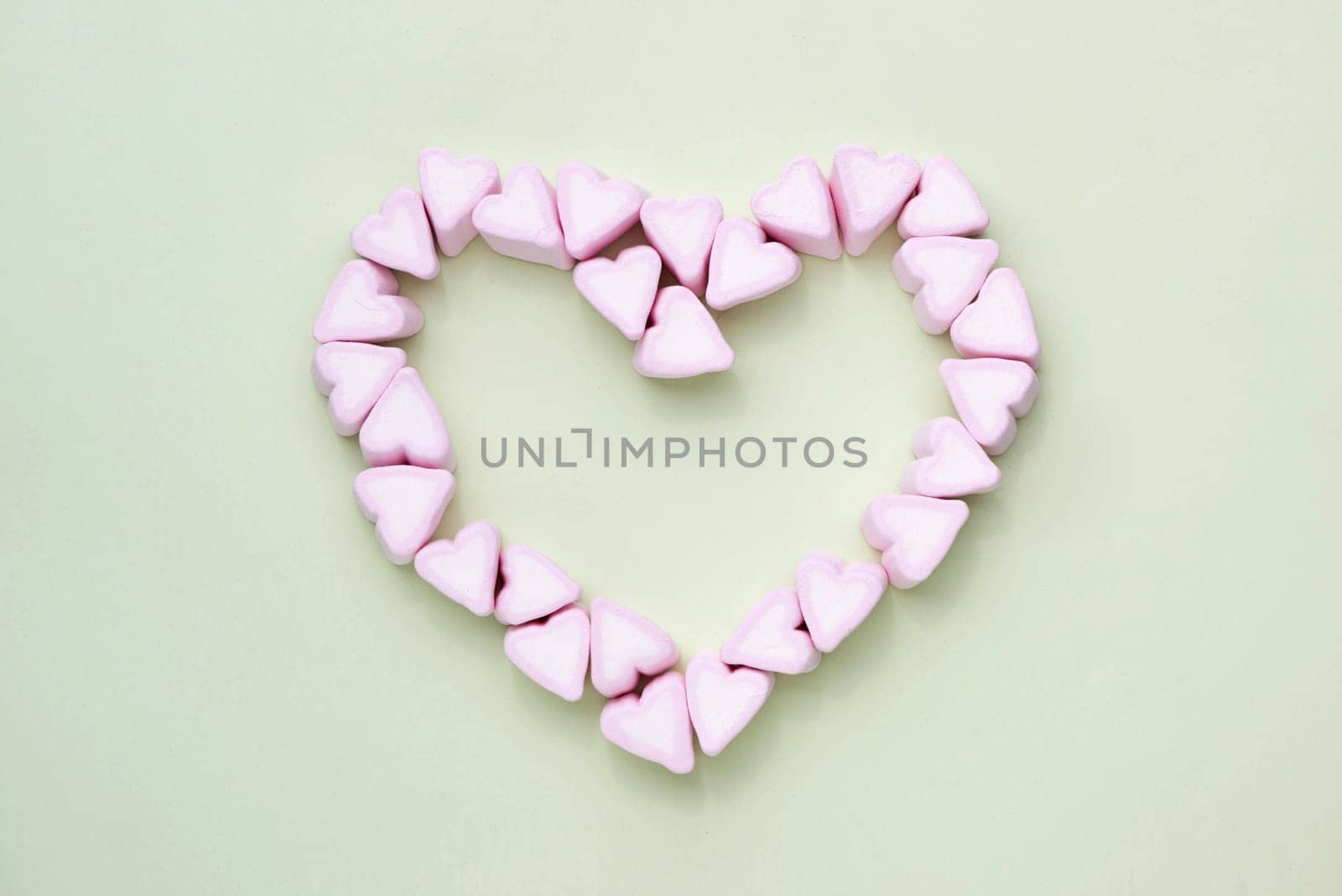 Valentines Day candy hearts marshmallows over green background