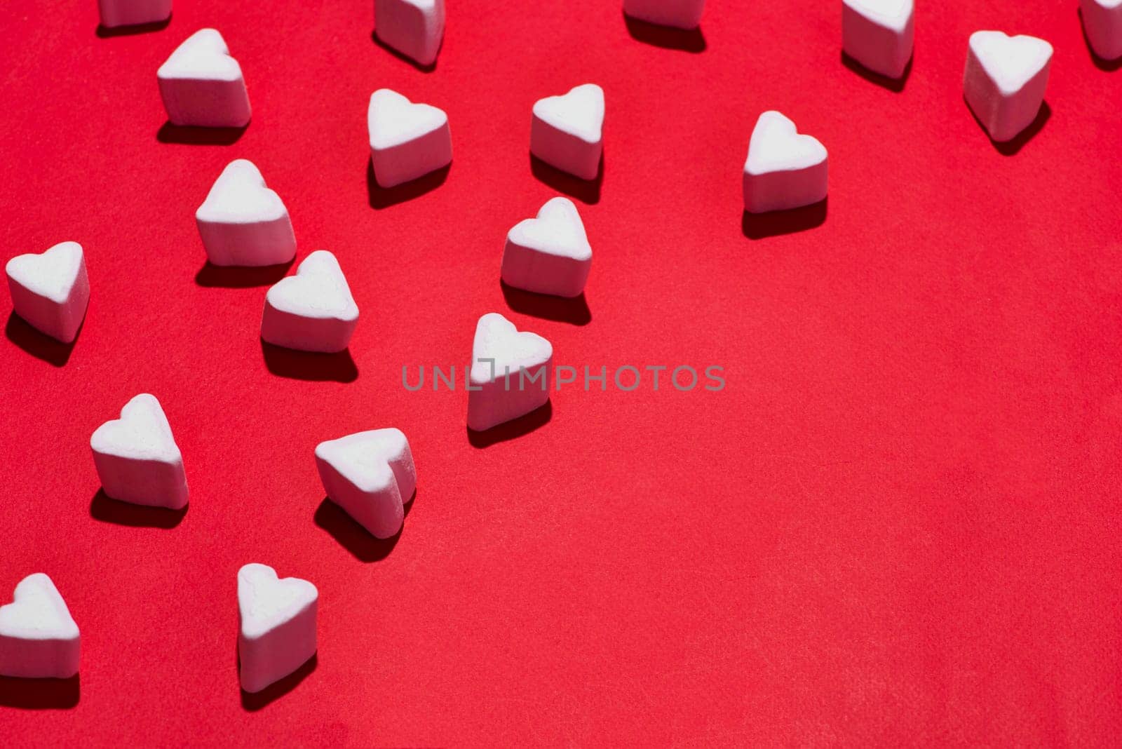 Valentines Day candy hearts marshmallows over red background