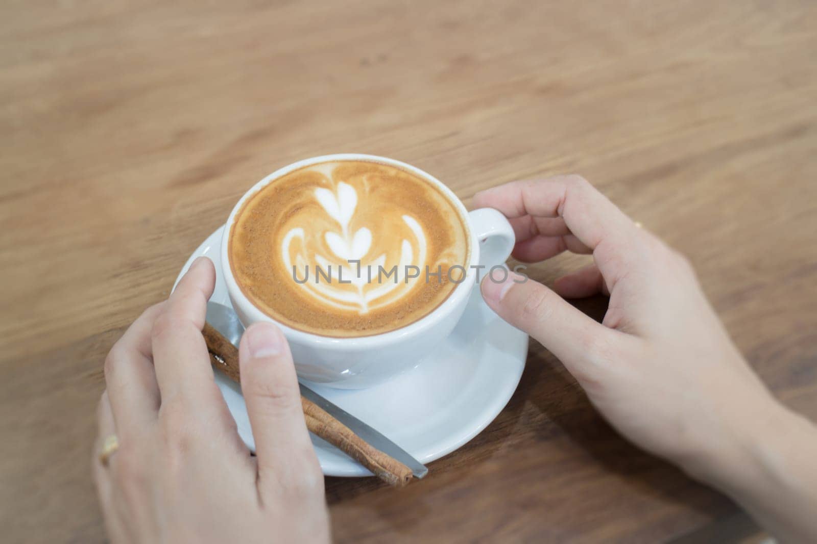 Hand On Hot Cup Of Coffee Latte, stock photo