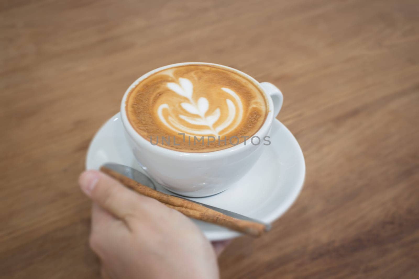 Hand On Hot Cup Of Coffee Latte, stock photo