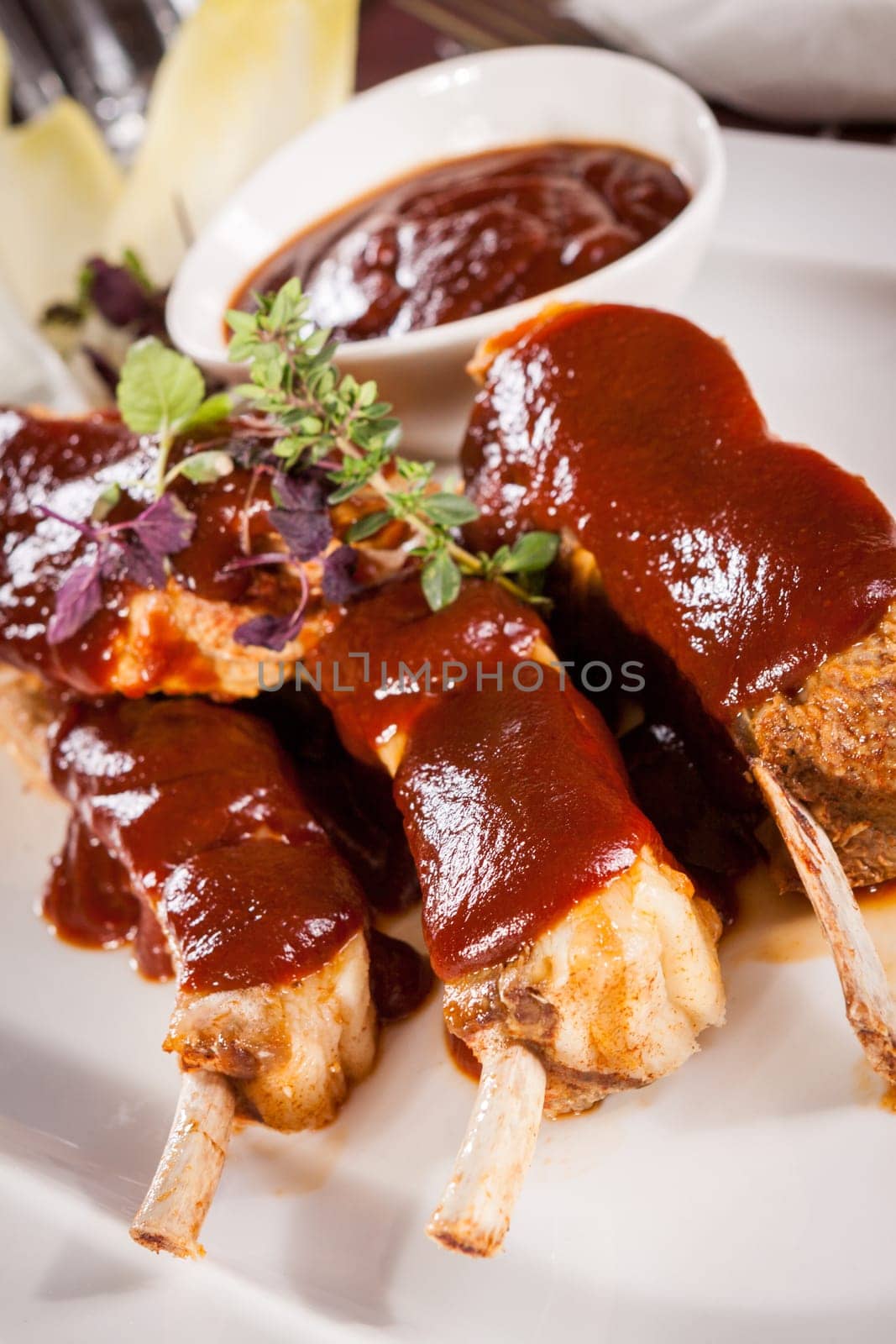 Grilled pork ribs Spareribs with barbecue sauce marinade and herb salad on a plate