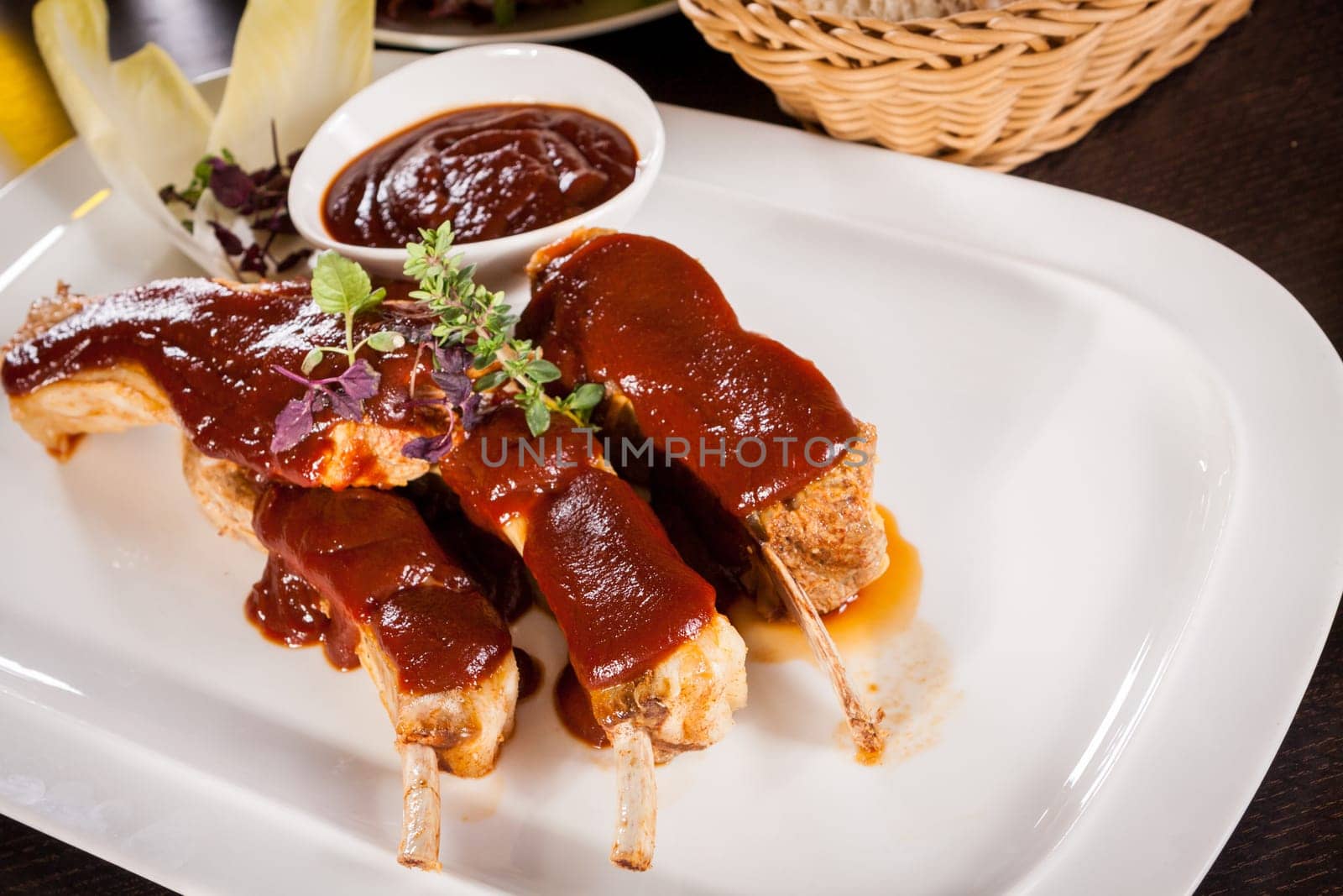 Grilled pork ribs Spareribs with barbecue sauce marinade and herb salad on a plate