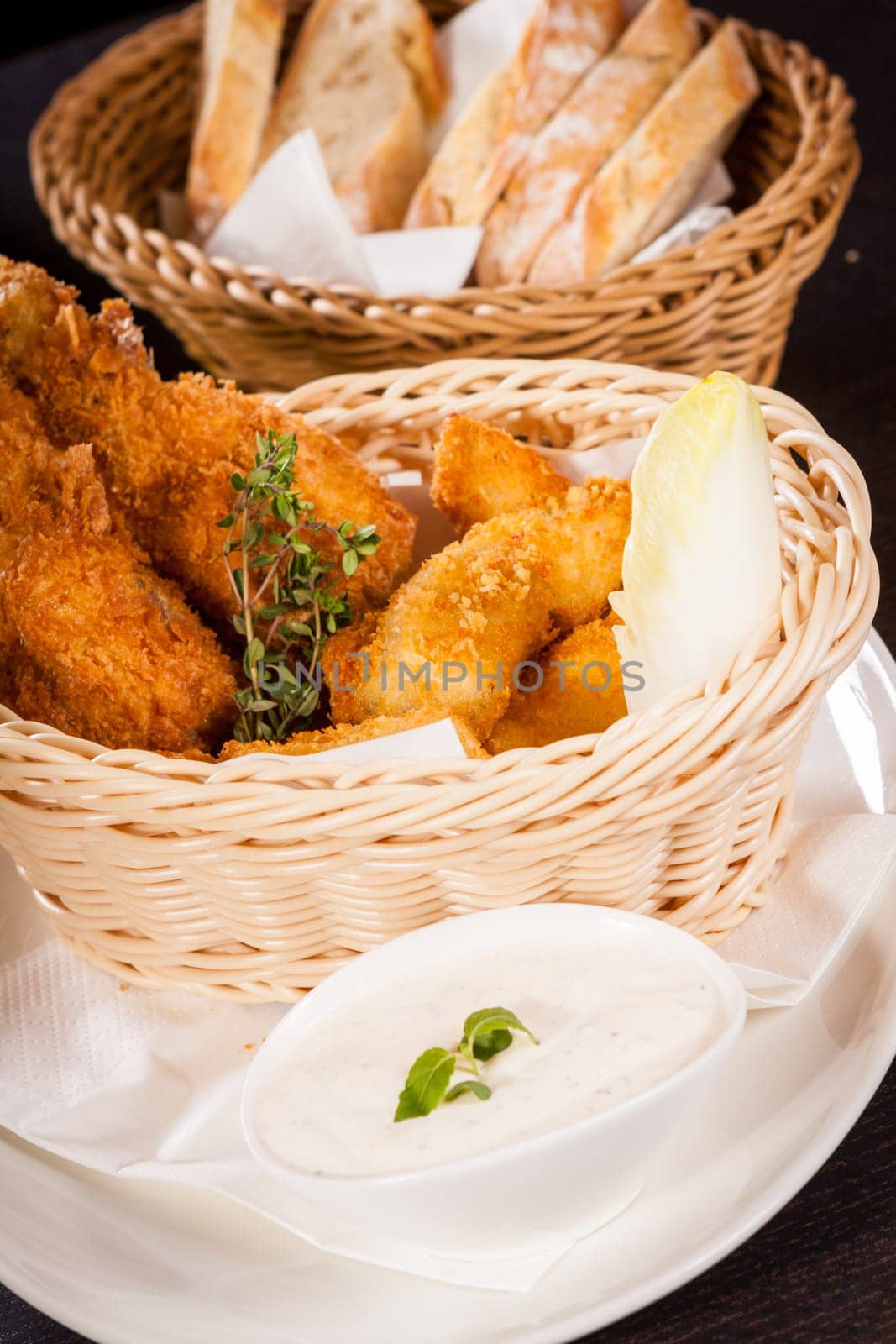 Crispy fried chicken wings with a dip on a plate