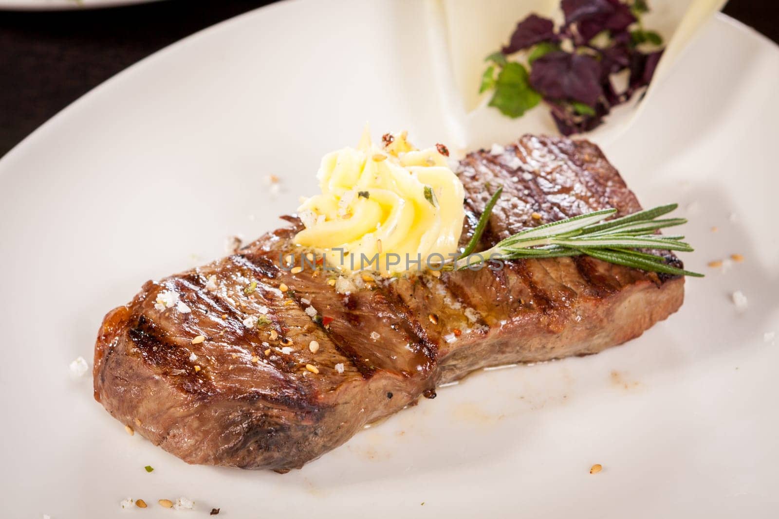 Succulent grilled beef fillet steak with homemade herb butter on a plate