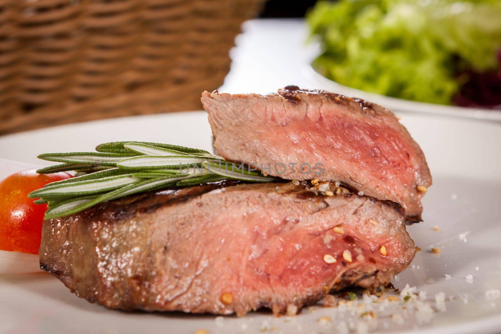 Medium fried beef steak fillet with pepper and rosemary sliced on a plate