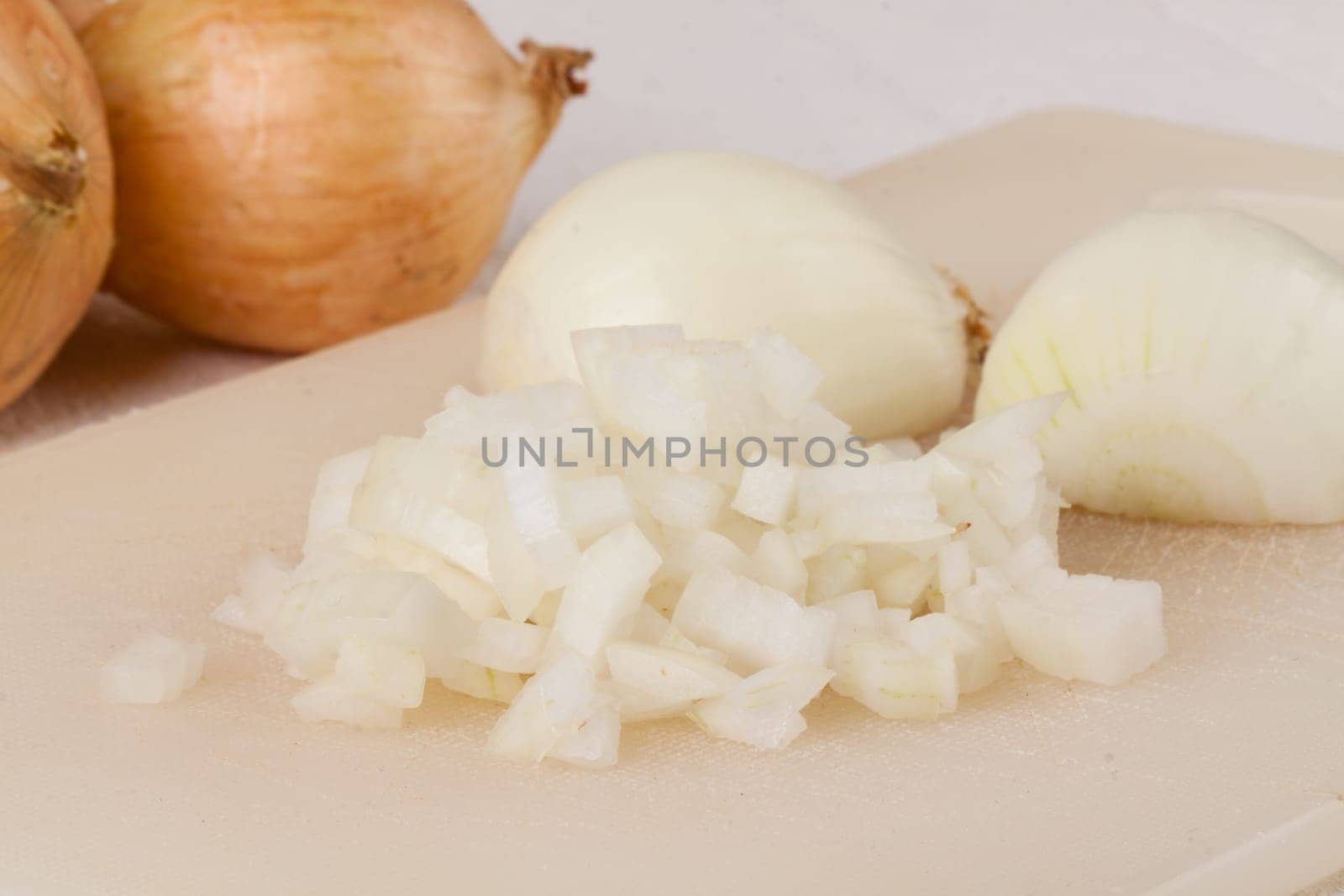White and red onions peeled and with slurs as a whole and in cubebrunoise as a close-up on cutting board