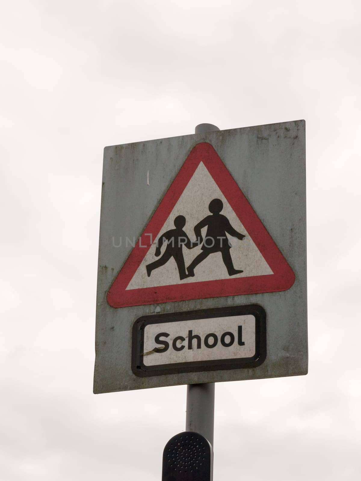 a red white and black school crossing sign with a cloudy sky background danger careful cars motor accidents careful parents and children