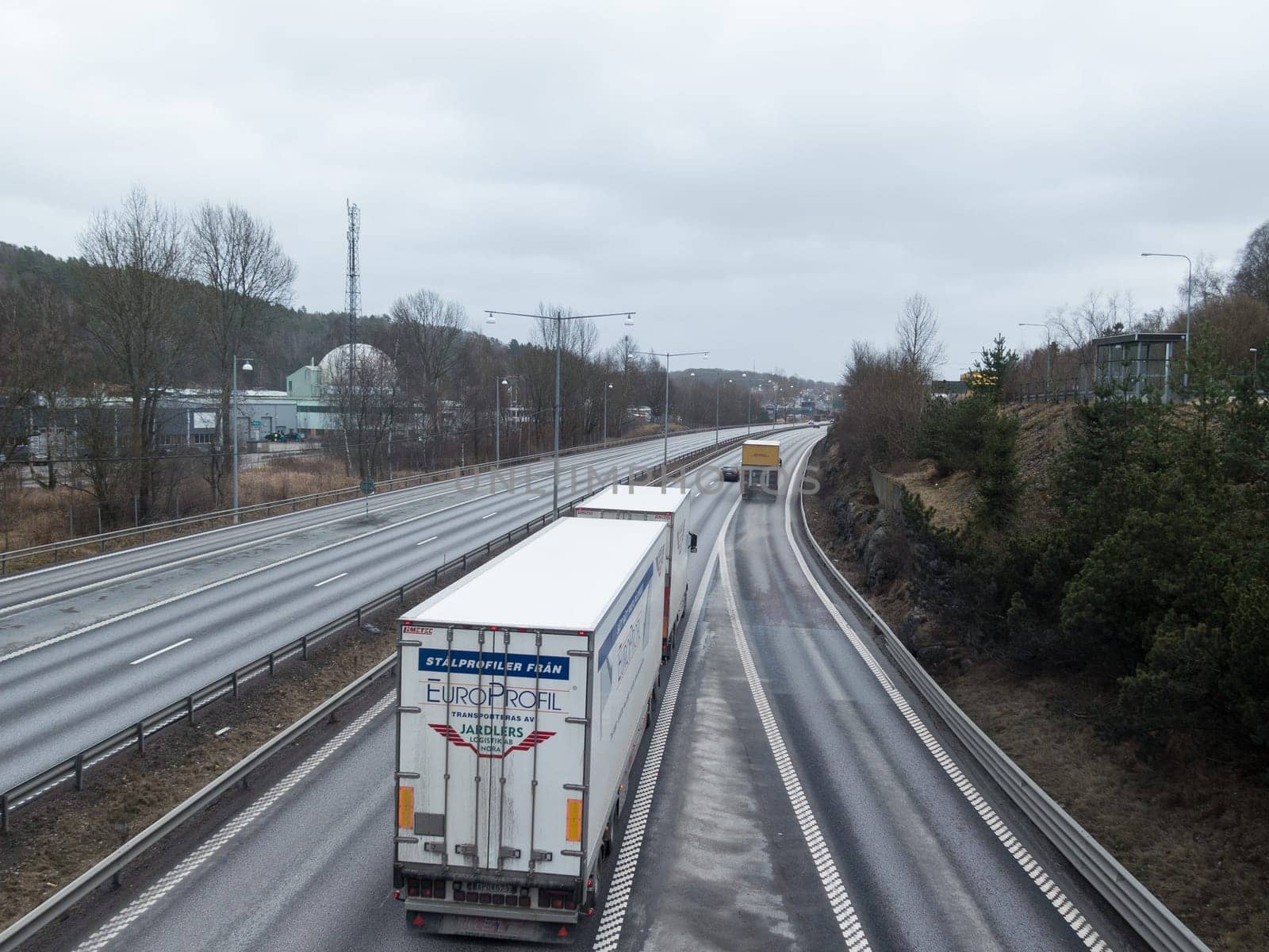 two big truck travelling on the motorway in to the city