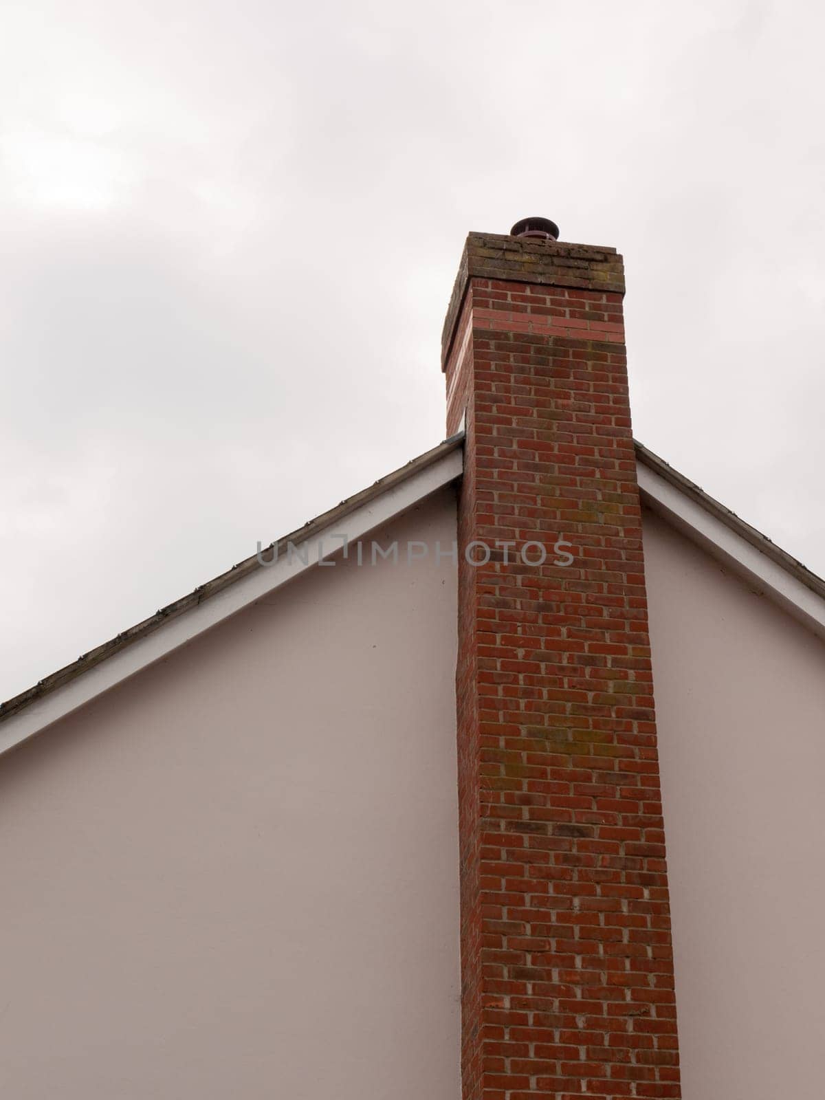 a large chimney on the side of a house with a sky background and white balls and roof top long high big bricks private homely fireplace
