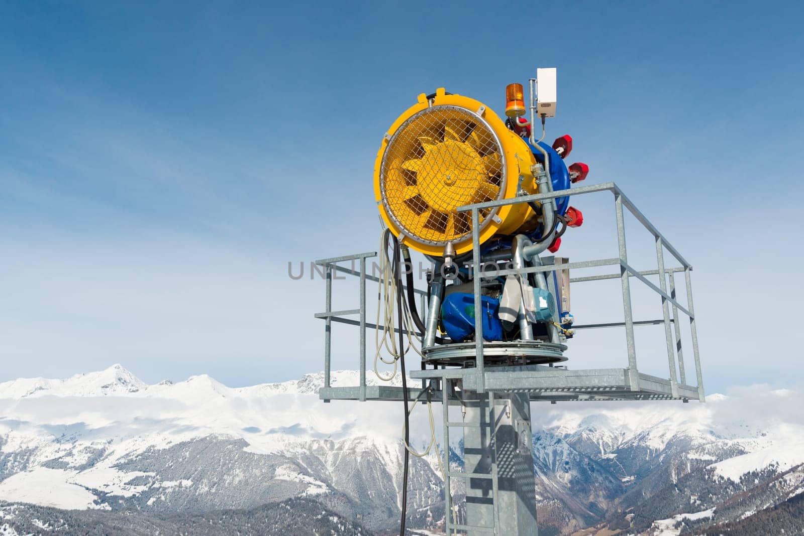 Snow cannon in front of a blue sky