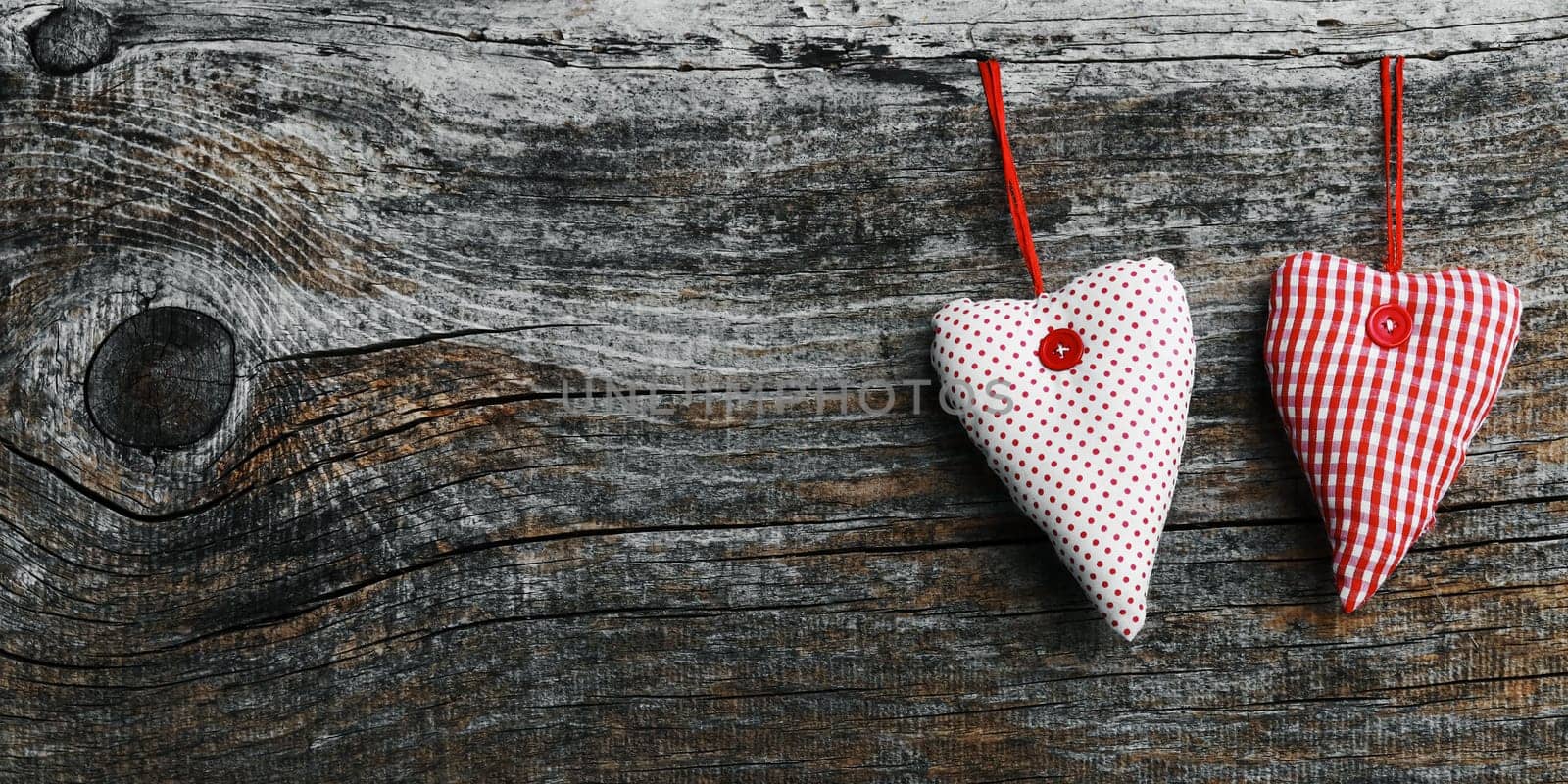 Two white-red fabric hearts on a dark wooden background in 18:9 format