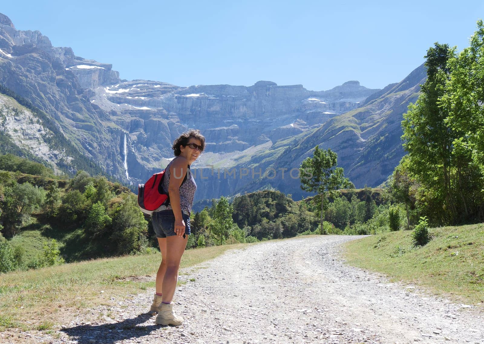 A woman hiker and cirque de Gavarnie in the French pyrenees mountains