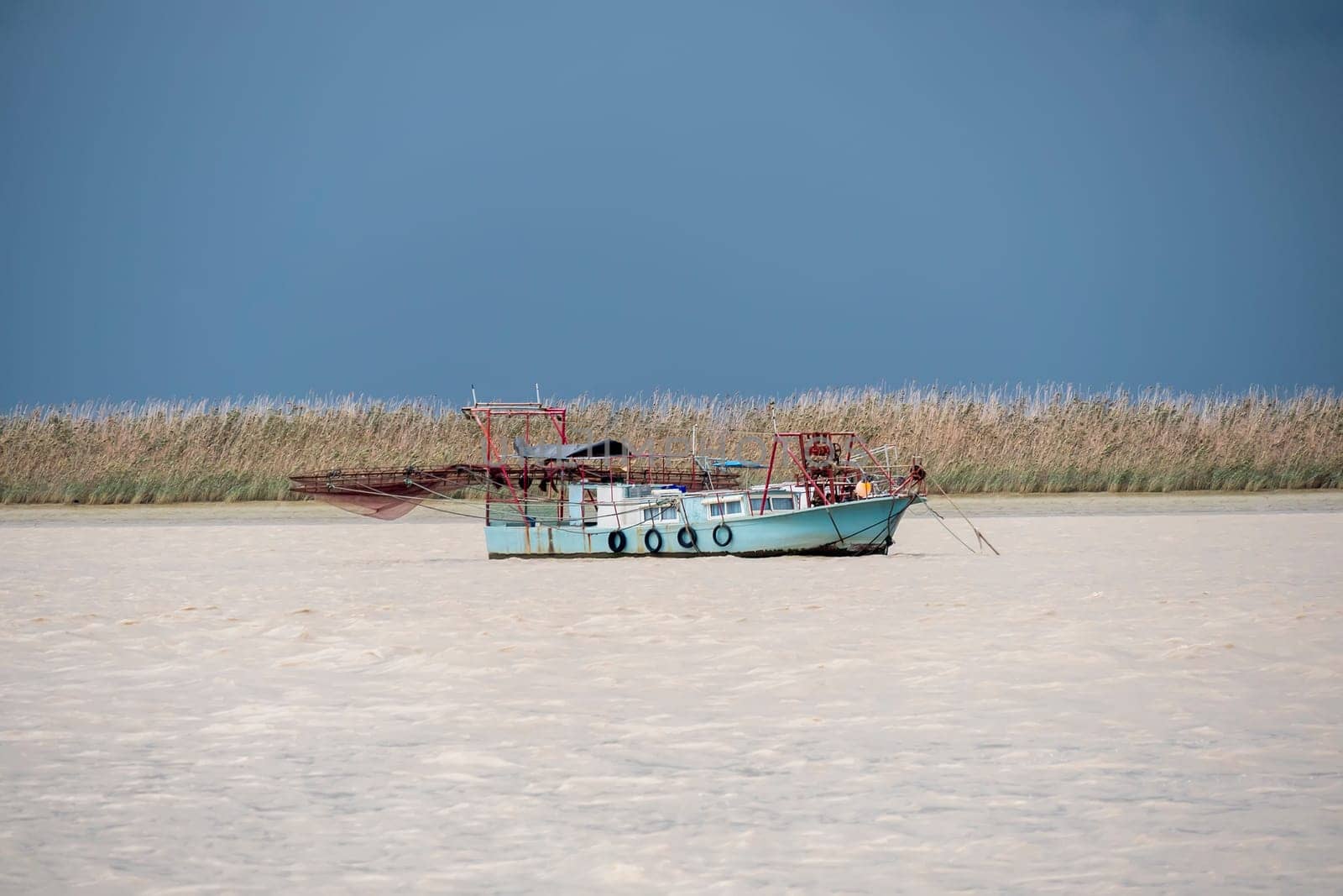 Fishing boat moving through the river on cloudy day