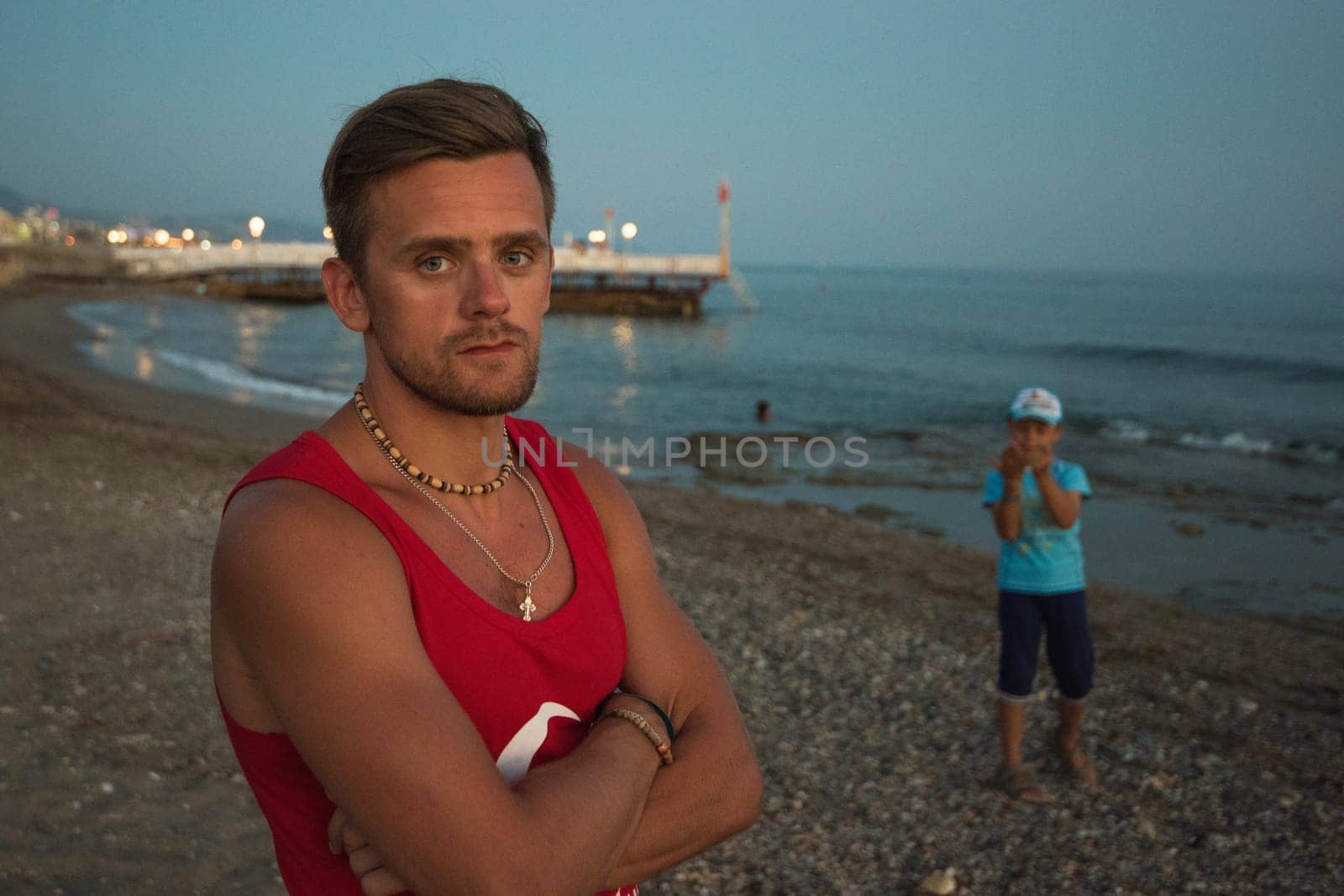 Young man at the evening sea with his son , on the beach at Alania, Turkey