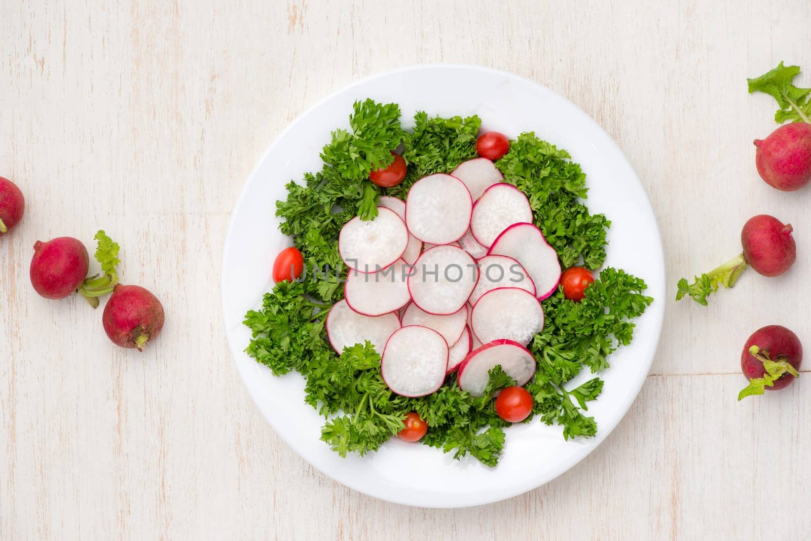 Homemade fresh radishes vegetable salad on table. Close-up.