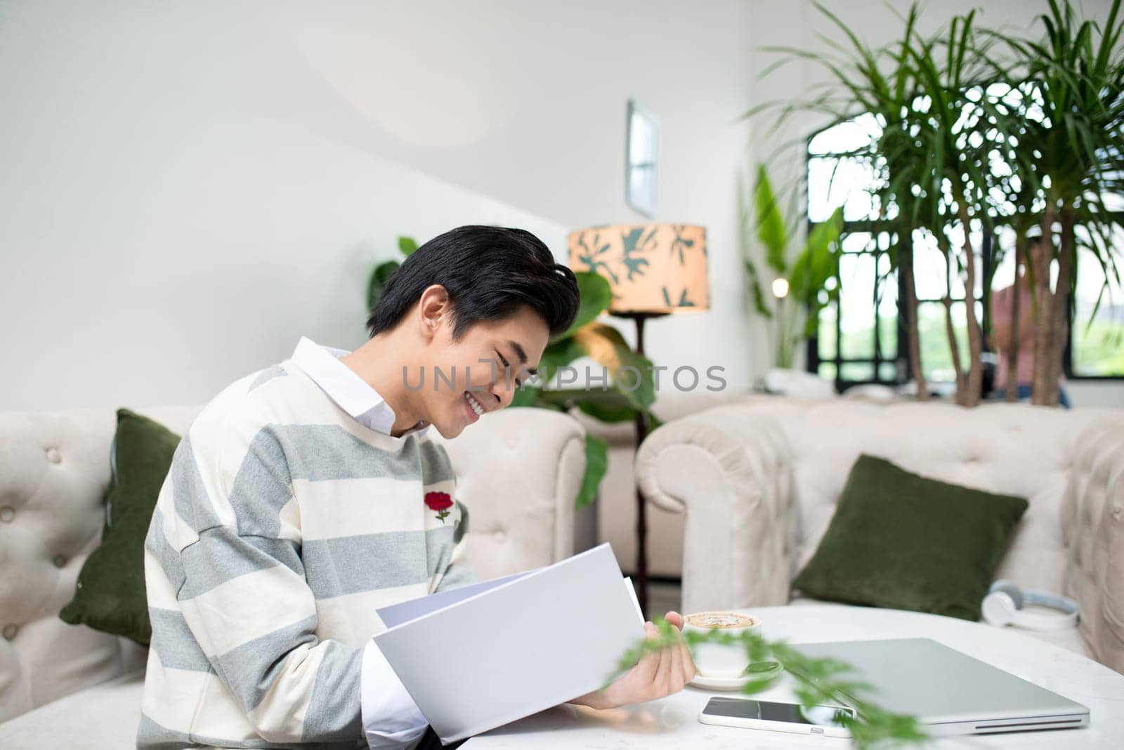 Asian entrepreneur reading book during coffee break
