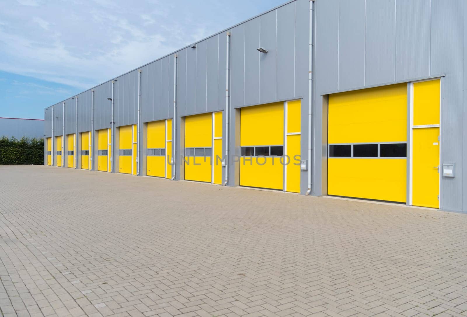 exterior of a commercial warehouse with yellow roller doors
