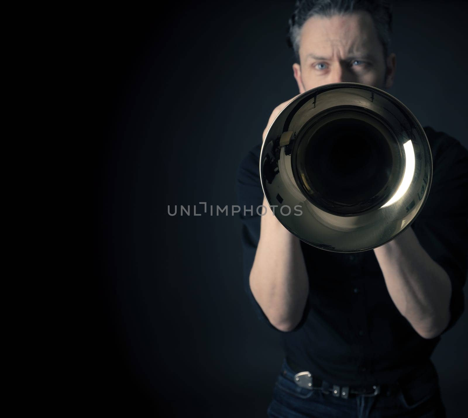 Dark portrait of a musician with a brass instrument