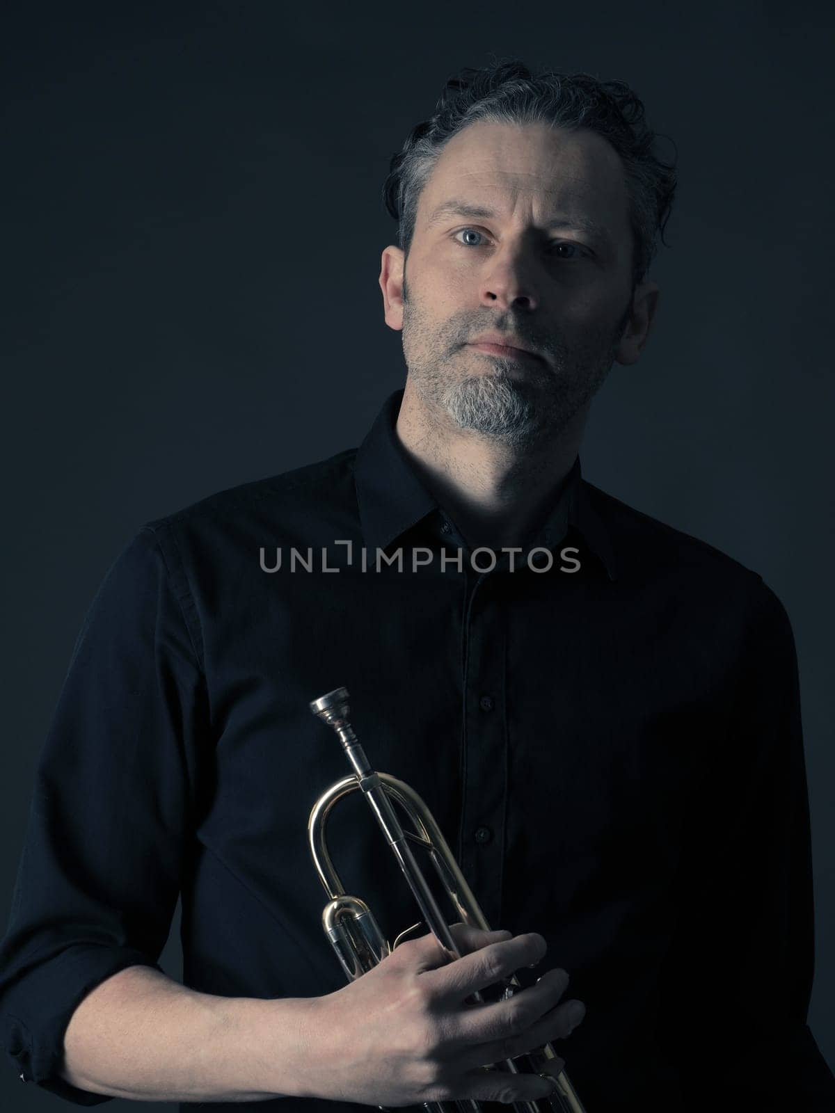 Dark portrait of a musician with a brass instrument
