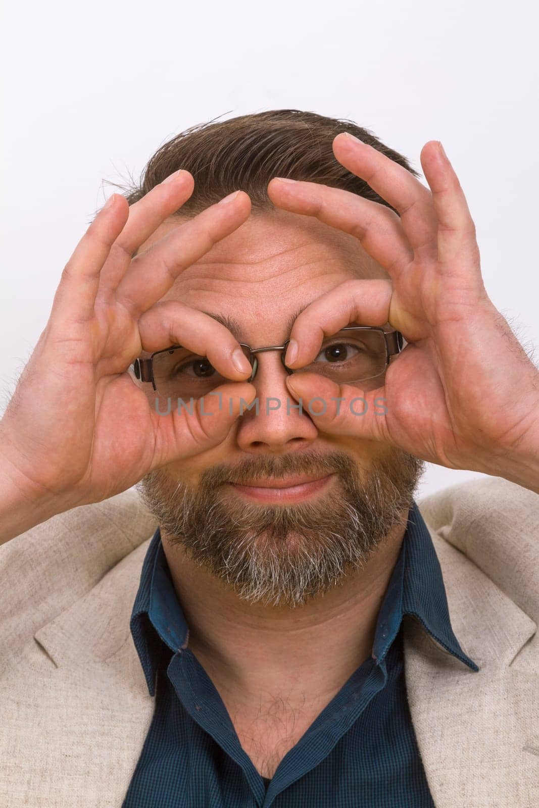 Man holds finger after eyes on a bright background