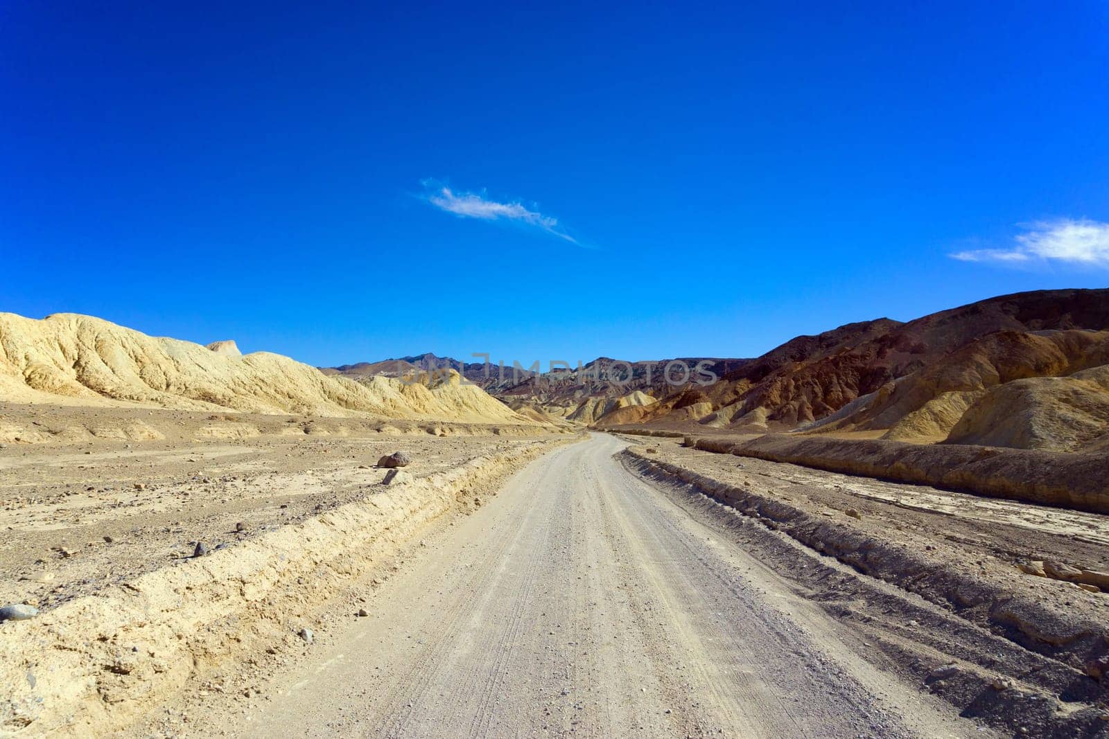 Dirt road passing through Badwater Basin in Death Valley National Park in California