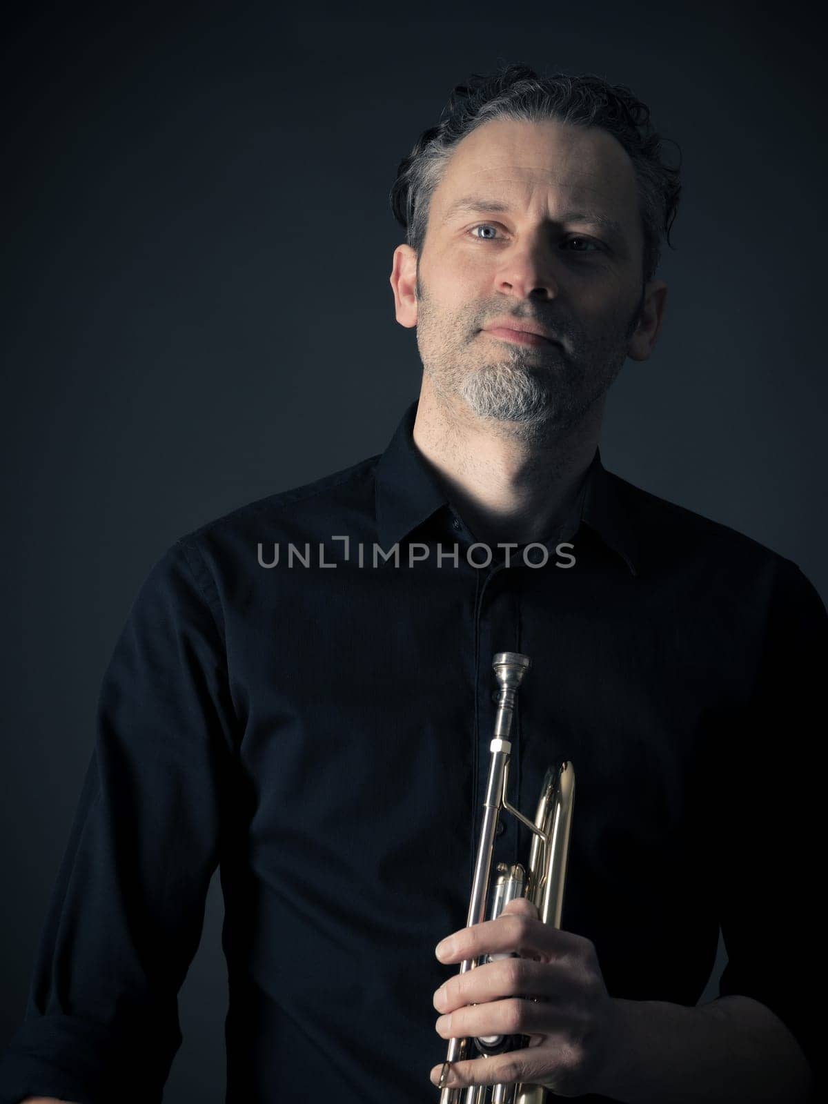 Dark portrait of a musician with a brass instrument