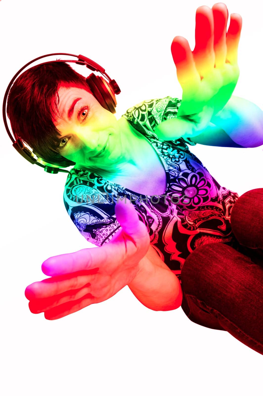 Colored upper body view of a black-haired middle-aged woman with headphones colorfully colored against a white background.