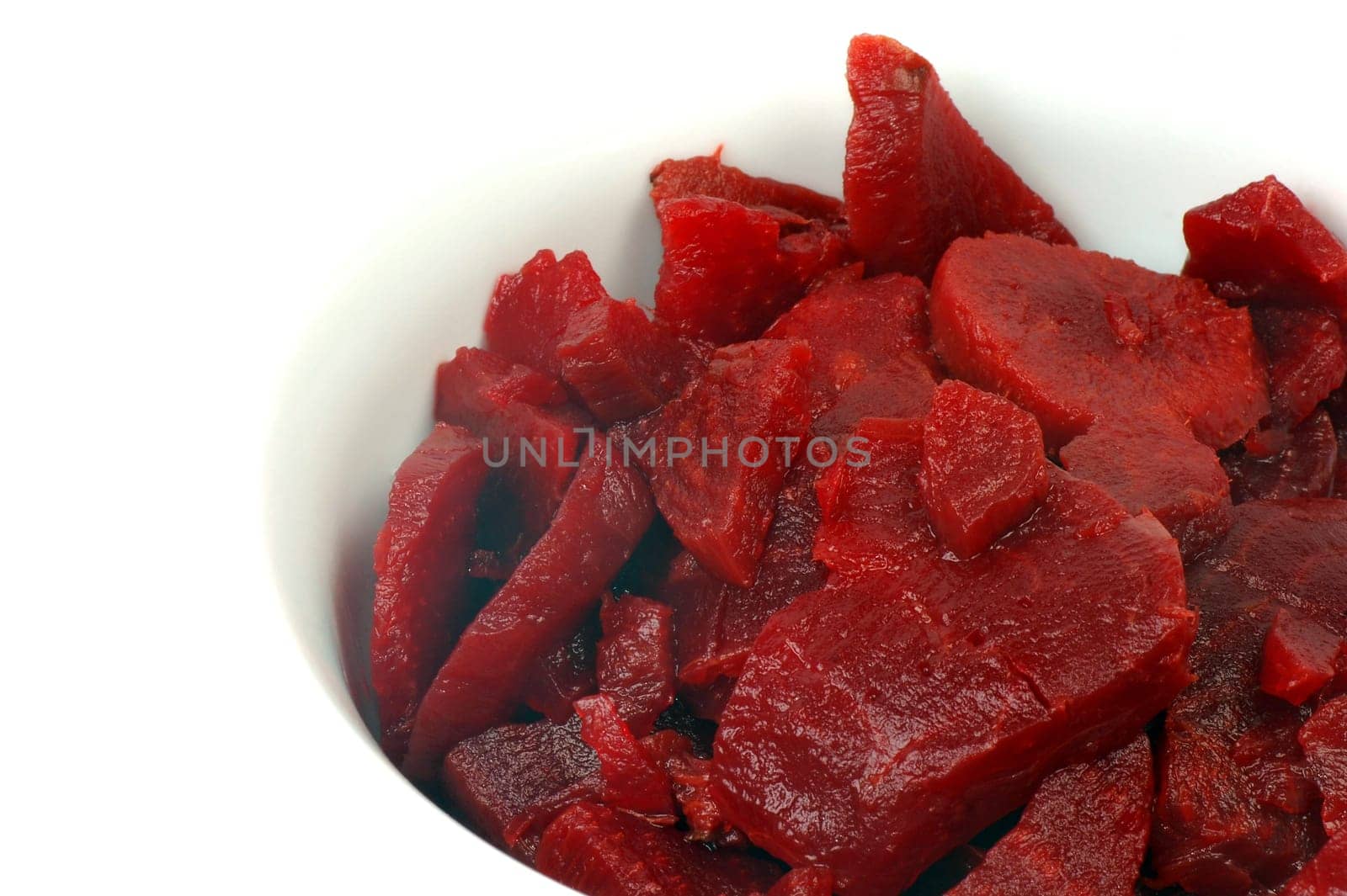 The beet salad is in white plate on white background.