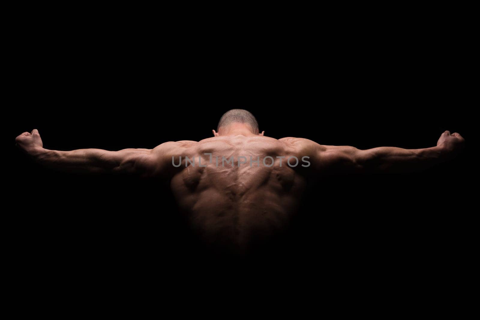 Muscular man's back in a dark background