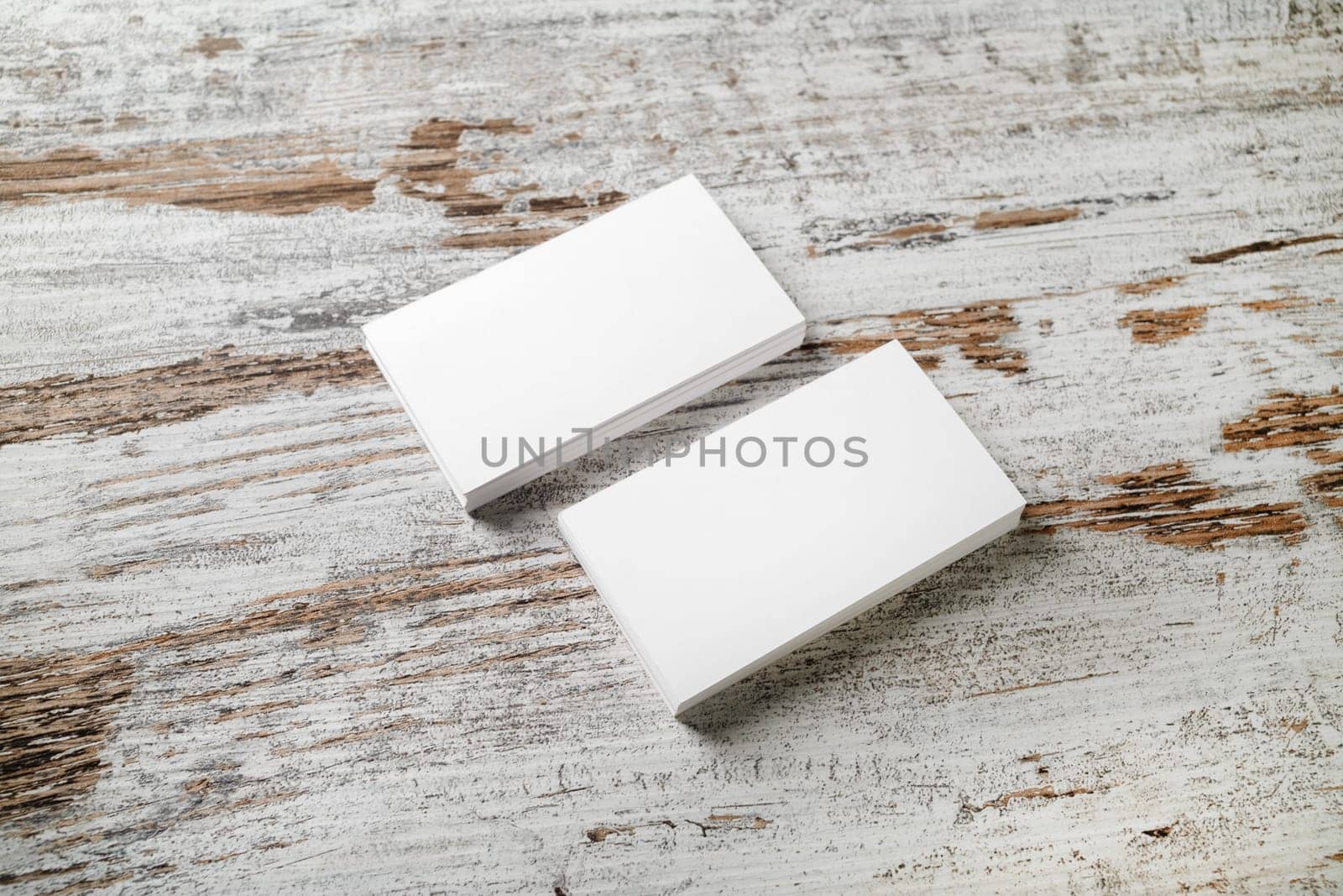 Mockup of blank business cards stack on wooden table background. For design presentations and portfolios. Selective focus.