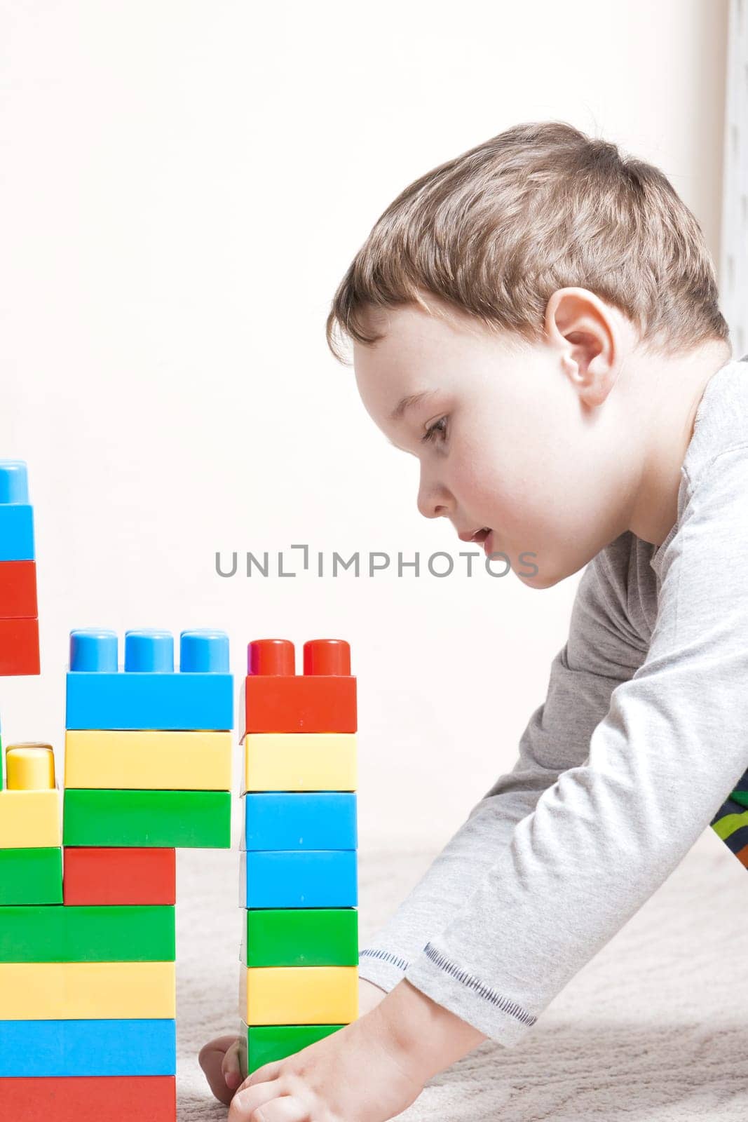 Playing little boy with colored cubes