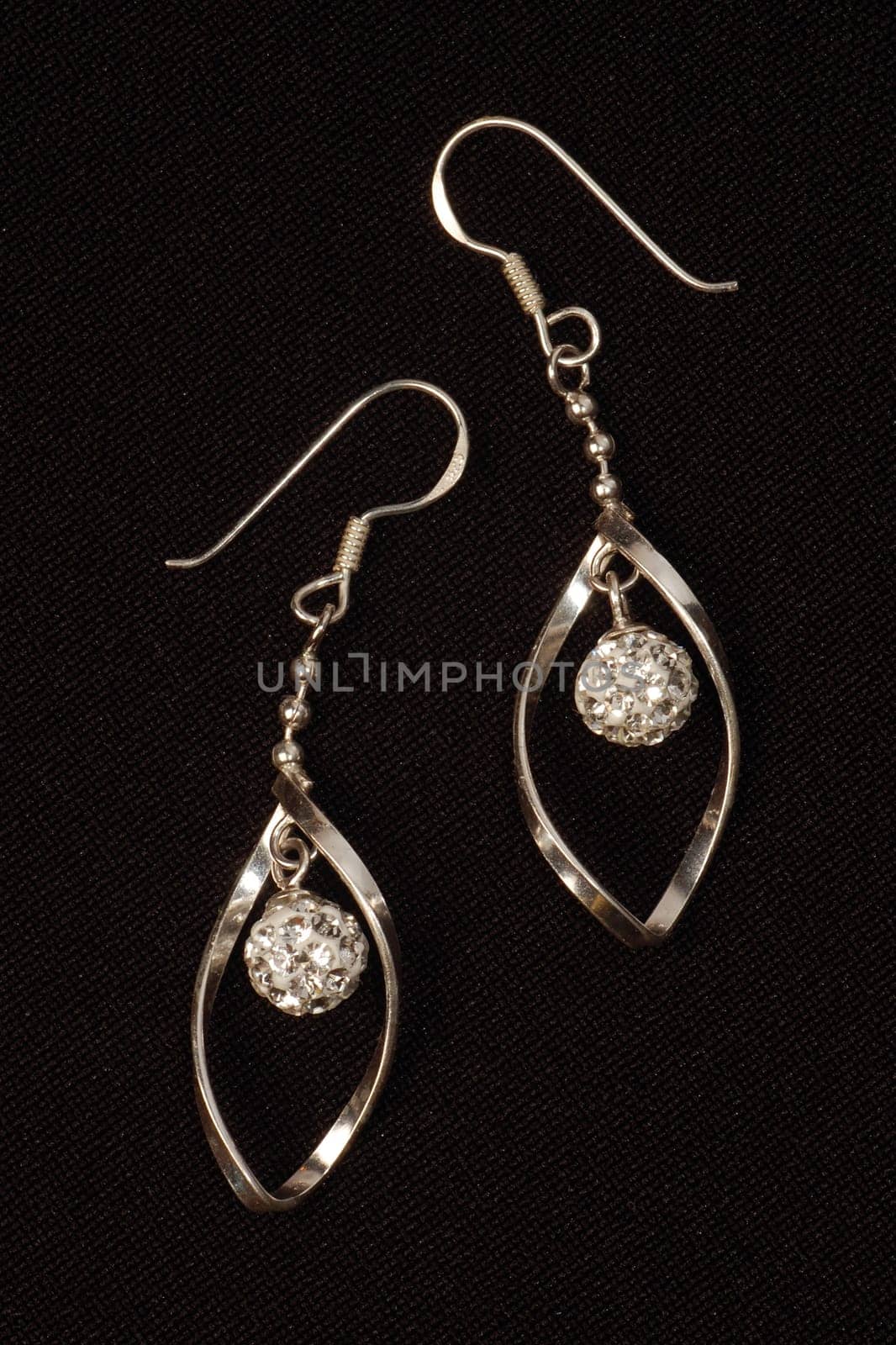 The silver earrings are on black background.