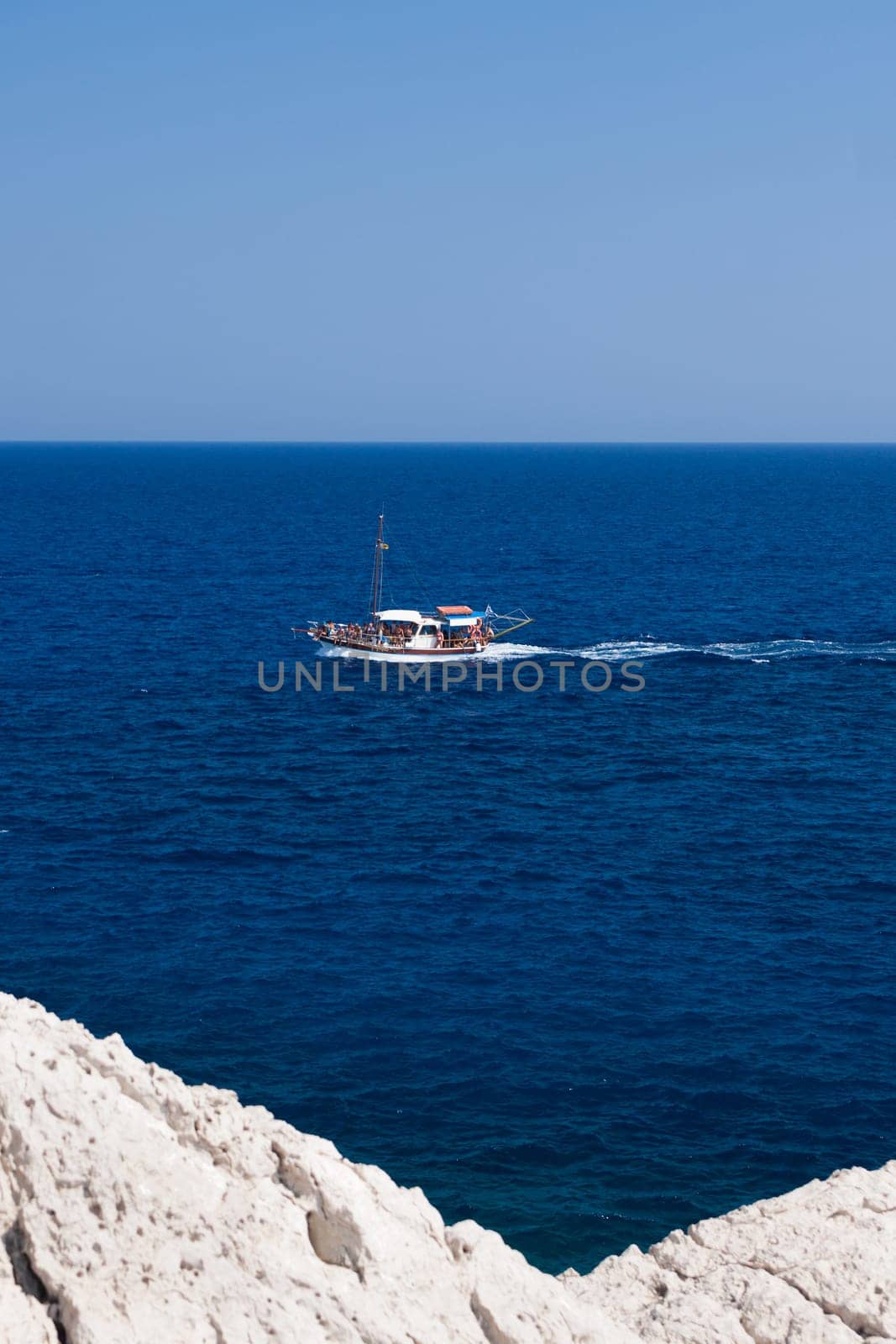 Kolymbia beach with the rocky coast in Greece. Motorboat and speed  in blue sea.