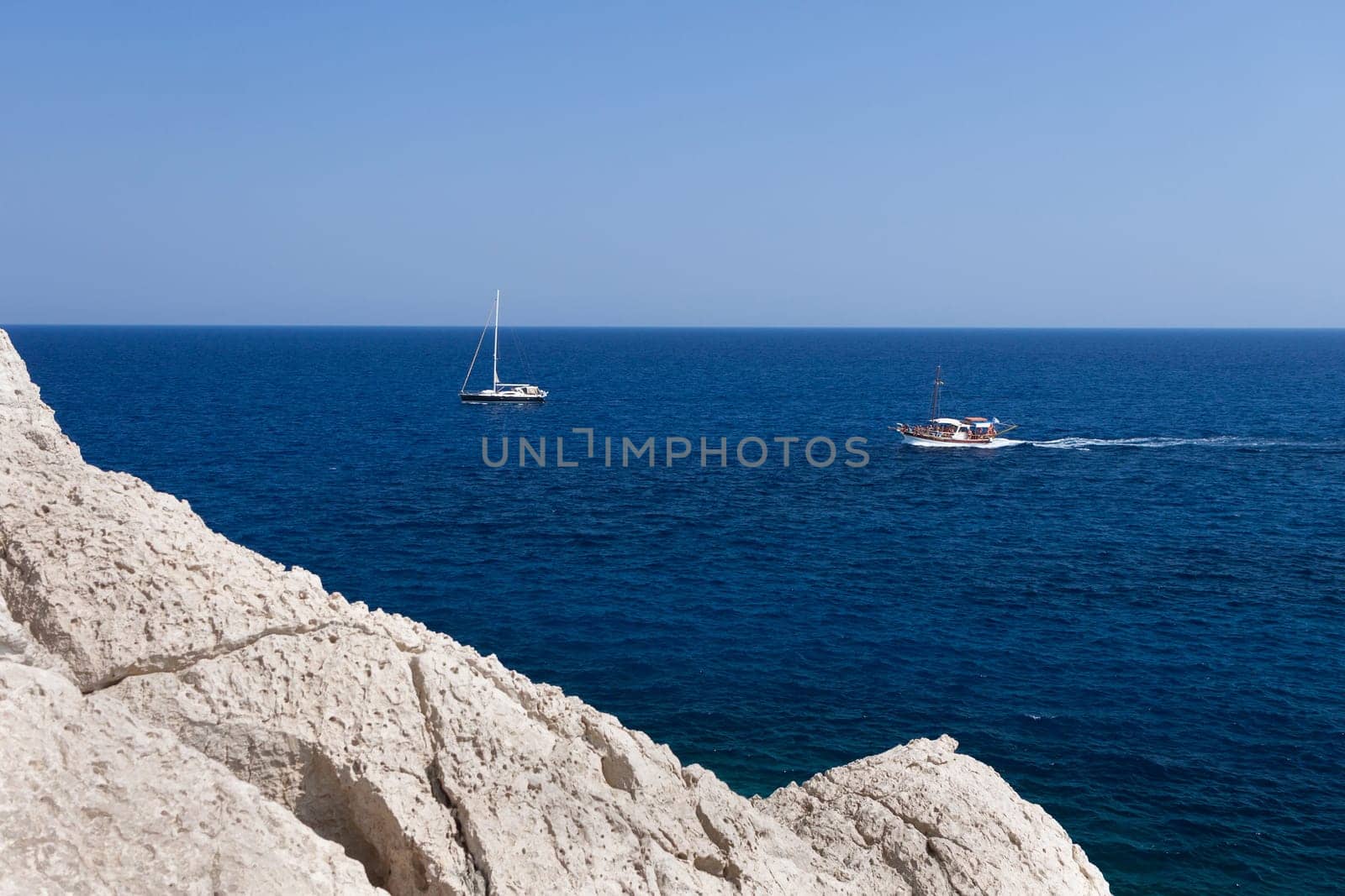 Kolymbia beach with the rocky coast in Greece. Motorboat and speed  in blue sea.