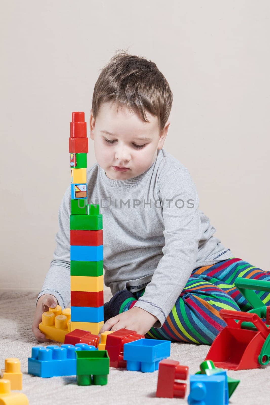 Playing little boy with colored cubes
