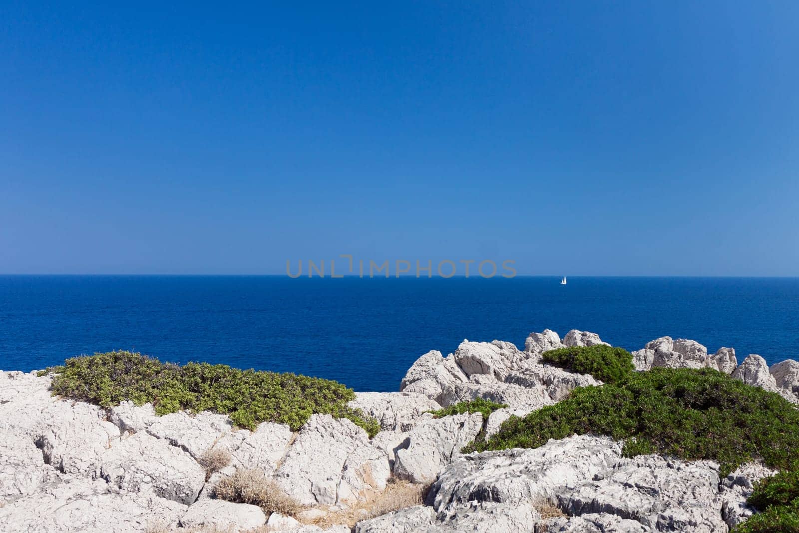 Kolymbia beach with the rocky coast in Greece. Motorboat and speed  in blue sea.