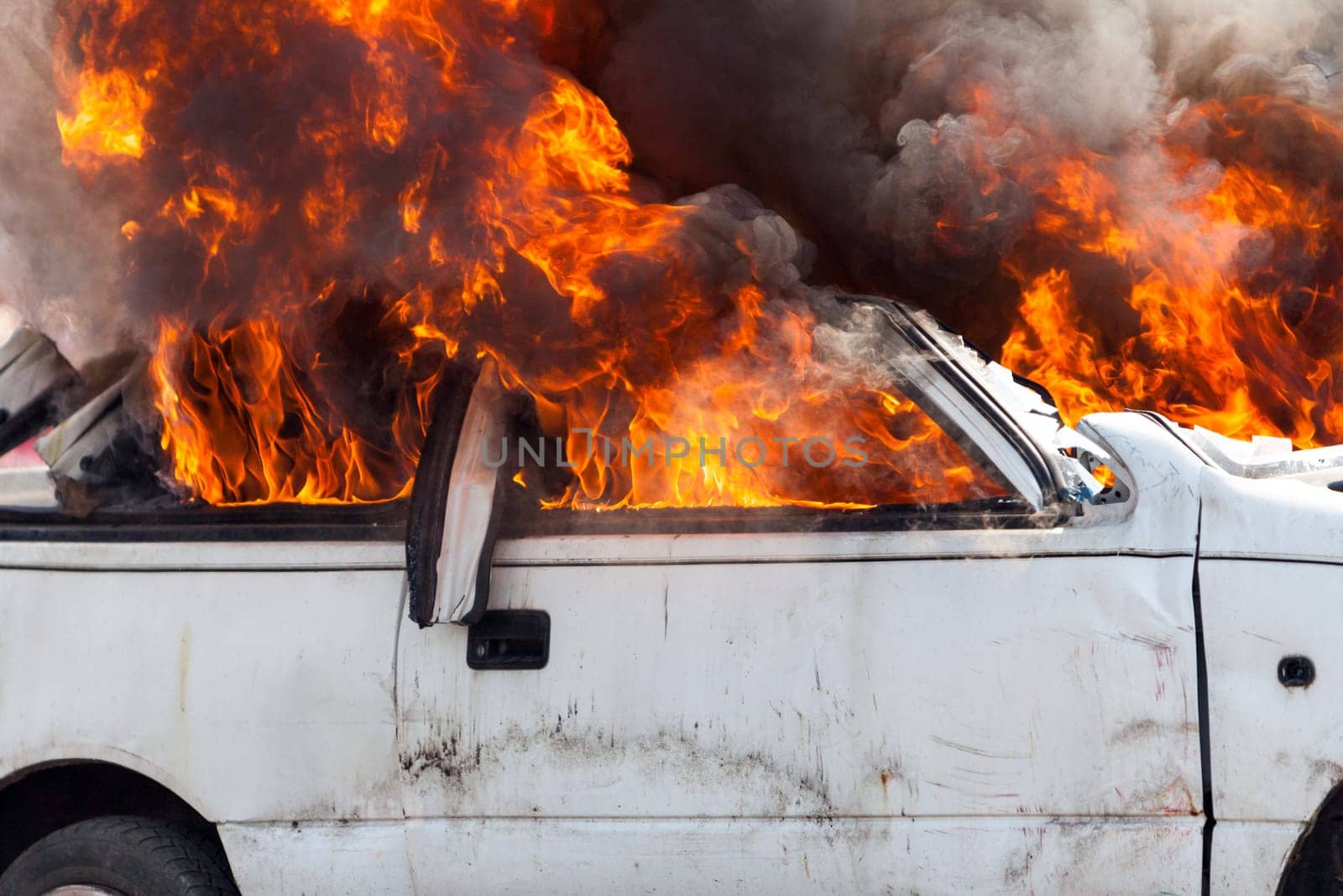 burning and then extinguish an old white car - Exercise firefighters