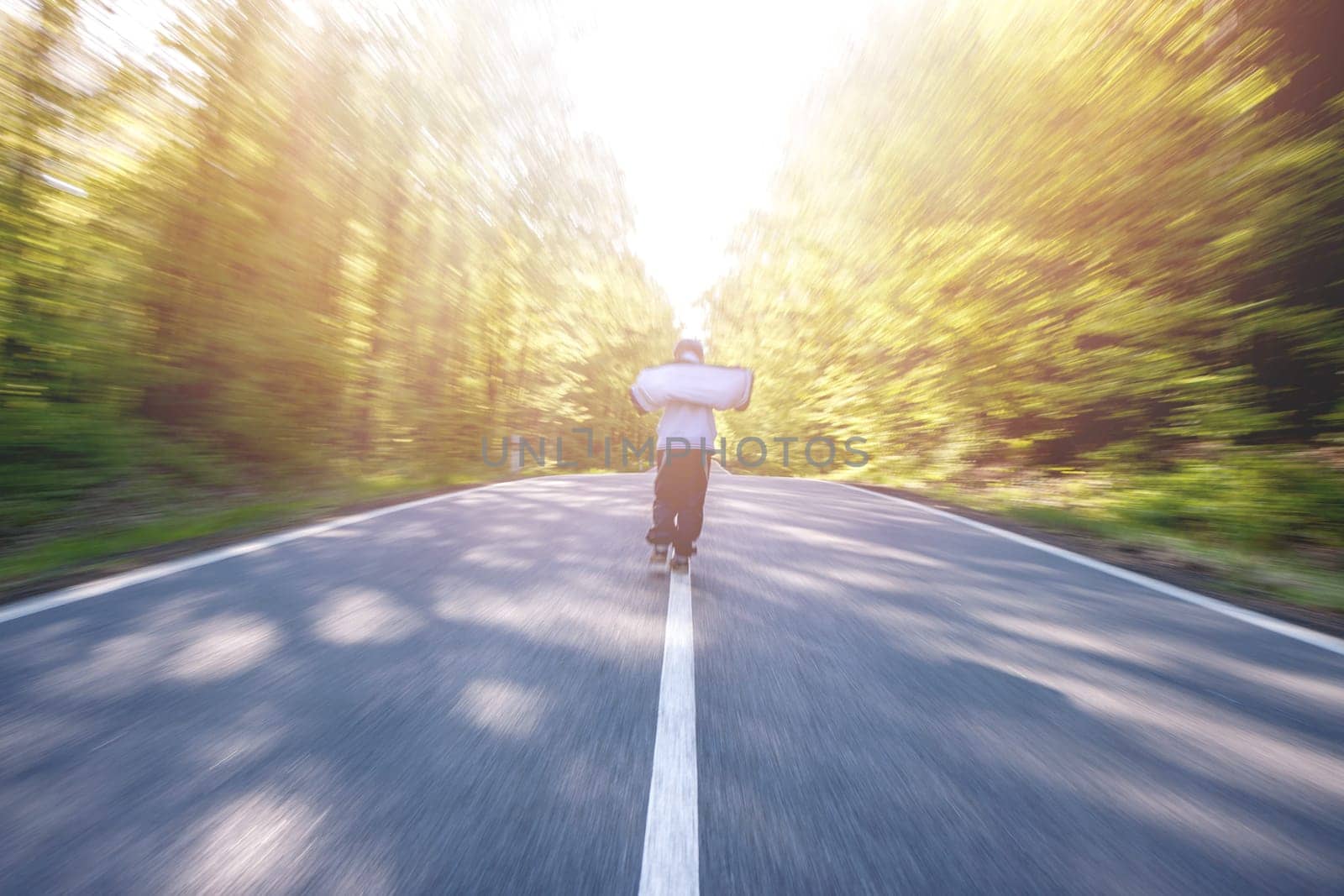Panning shot of boy walking through a road in the middle of a forest