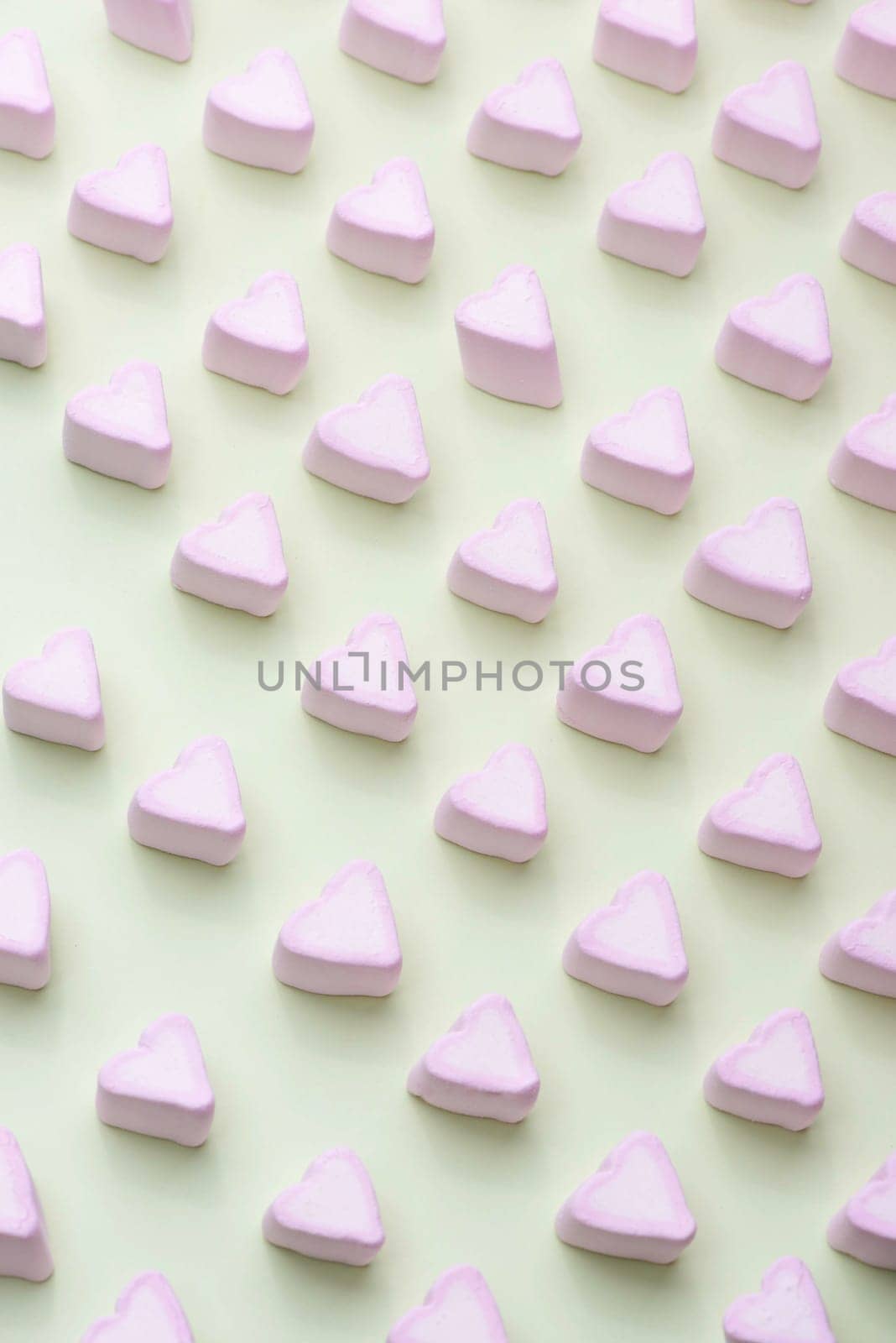 Valentines Day candy hearts marshmallows over green background