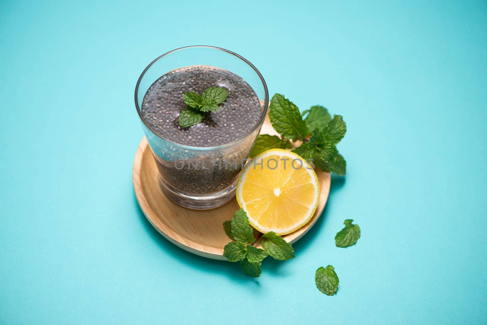 Selective focus of chia seeds drink with water in transparent glass with lemon balm.
