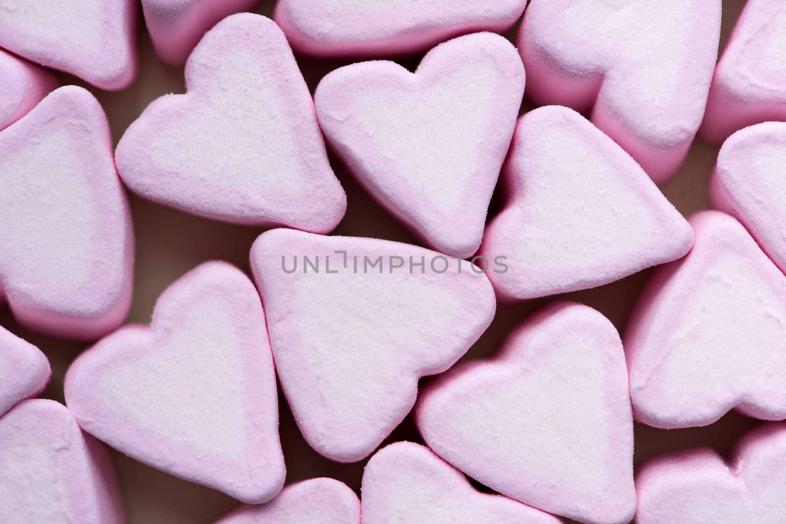 Valentines Day candy hearts marshmallows over green background