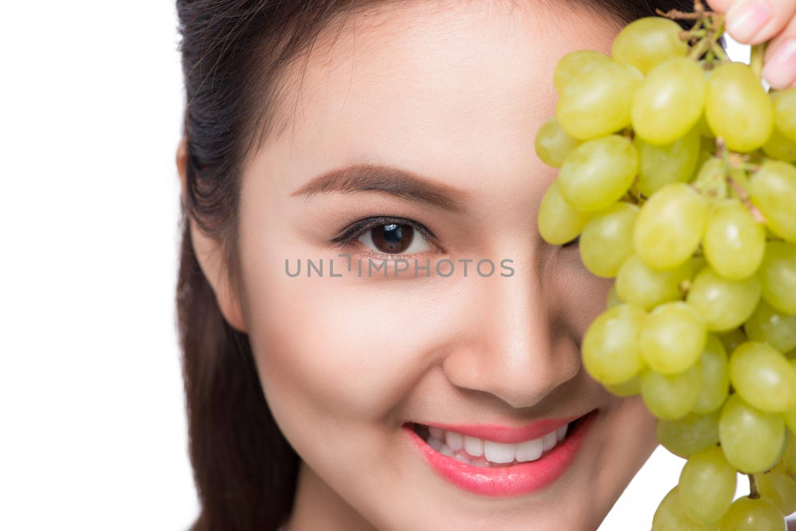 Young beautiful asian woman eating fresh grapes isolated on white background