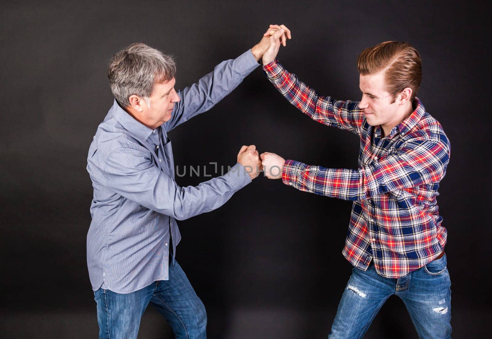 father and son lean on back to back isolated on black