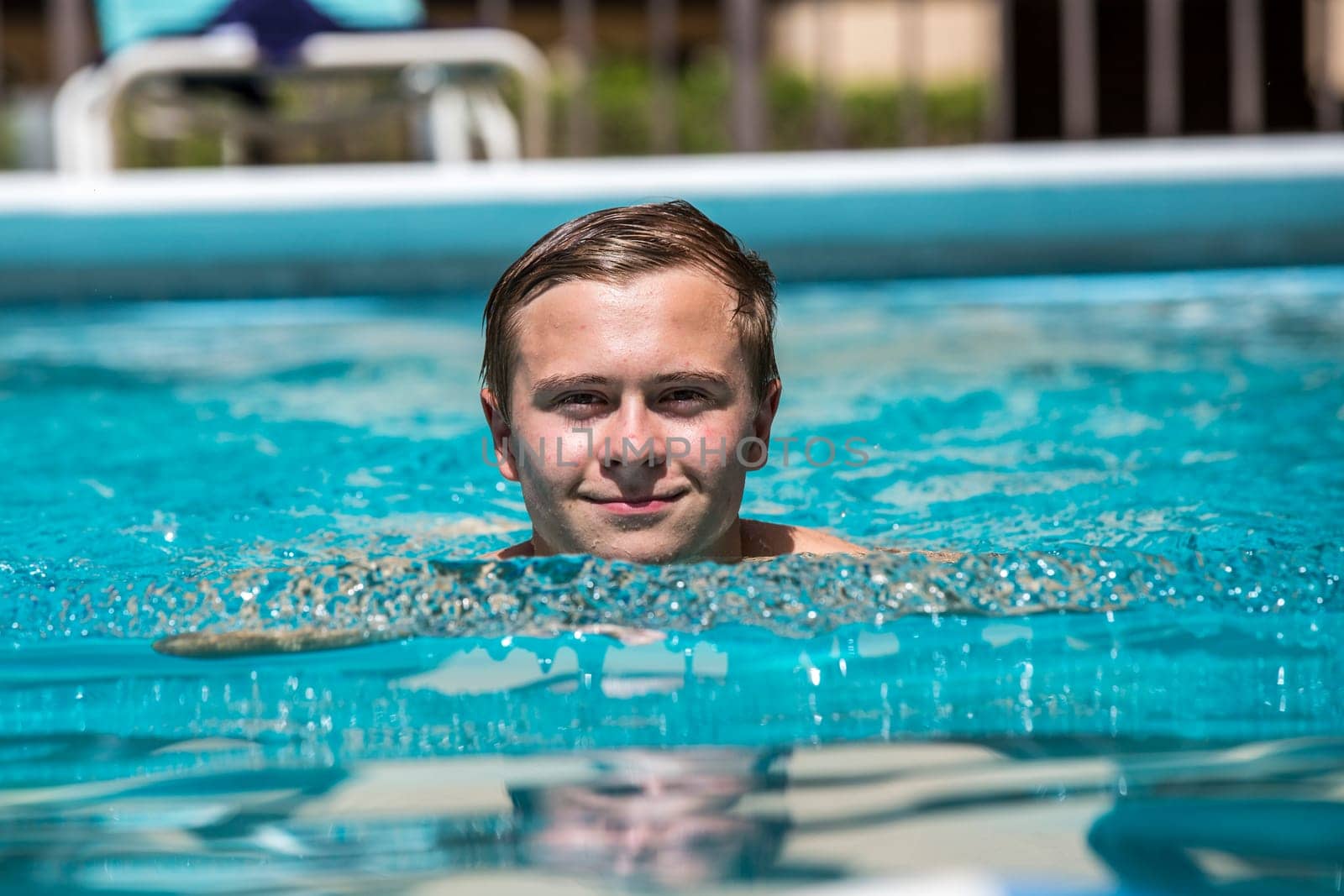 boy enjoys swimming in the outdoor swimming pool
