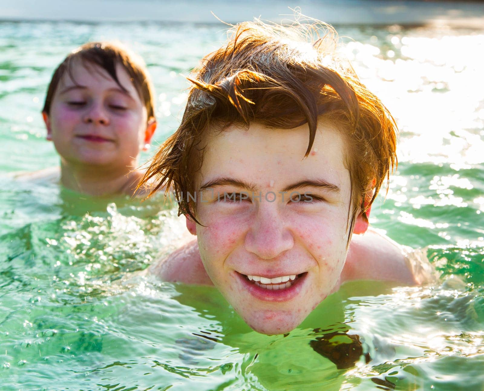 brothers are enjoying the clear warm water at the beautiful beach