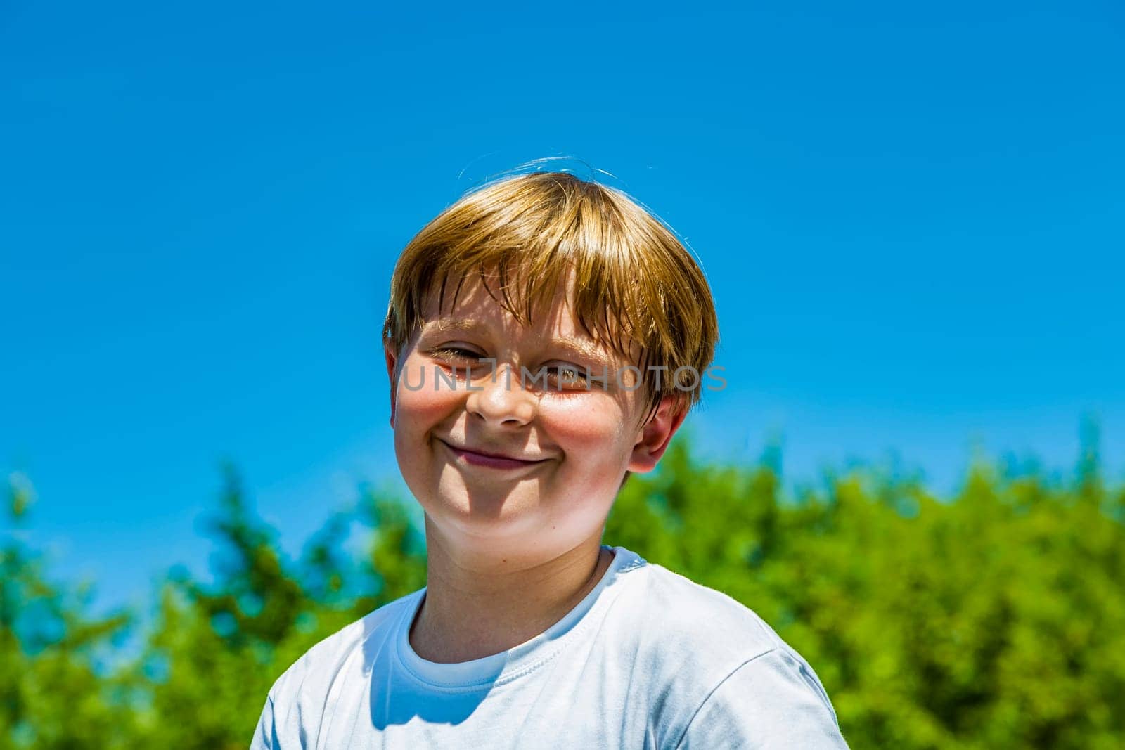 happy boy is smiling and enjoys life under blue sky