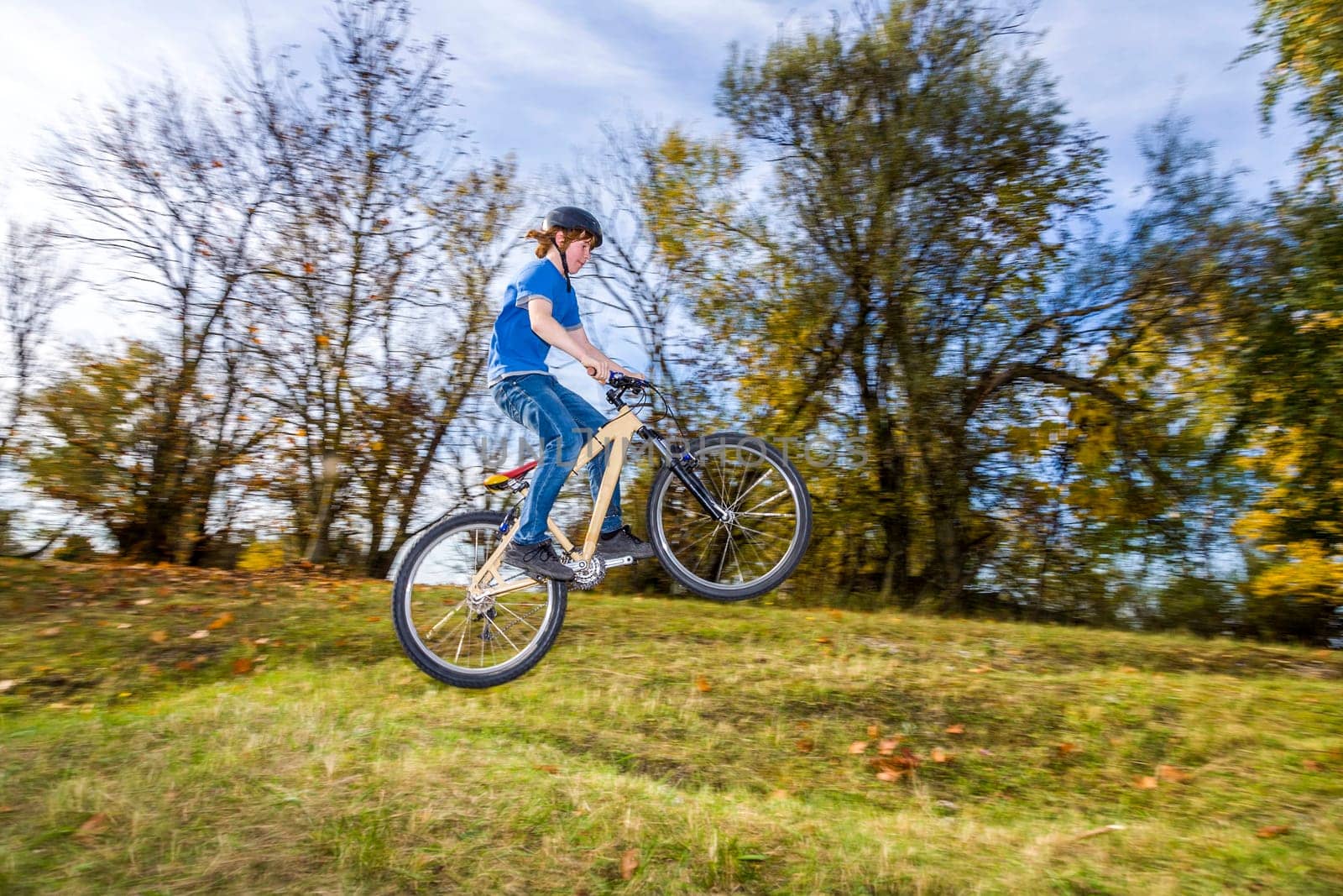 teenage boy jumps over a ramp with his dirt bike
