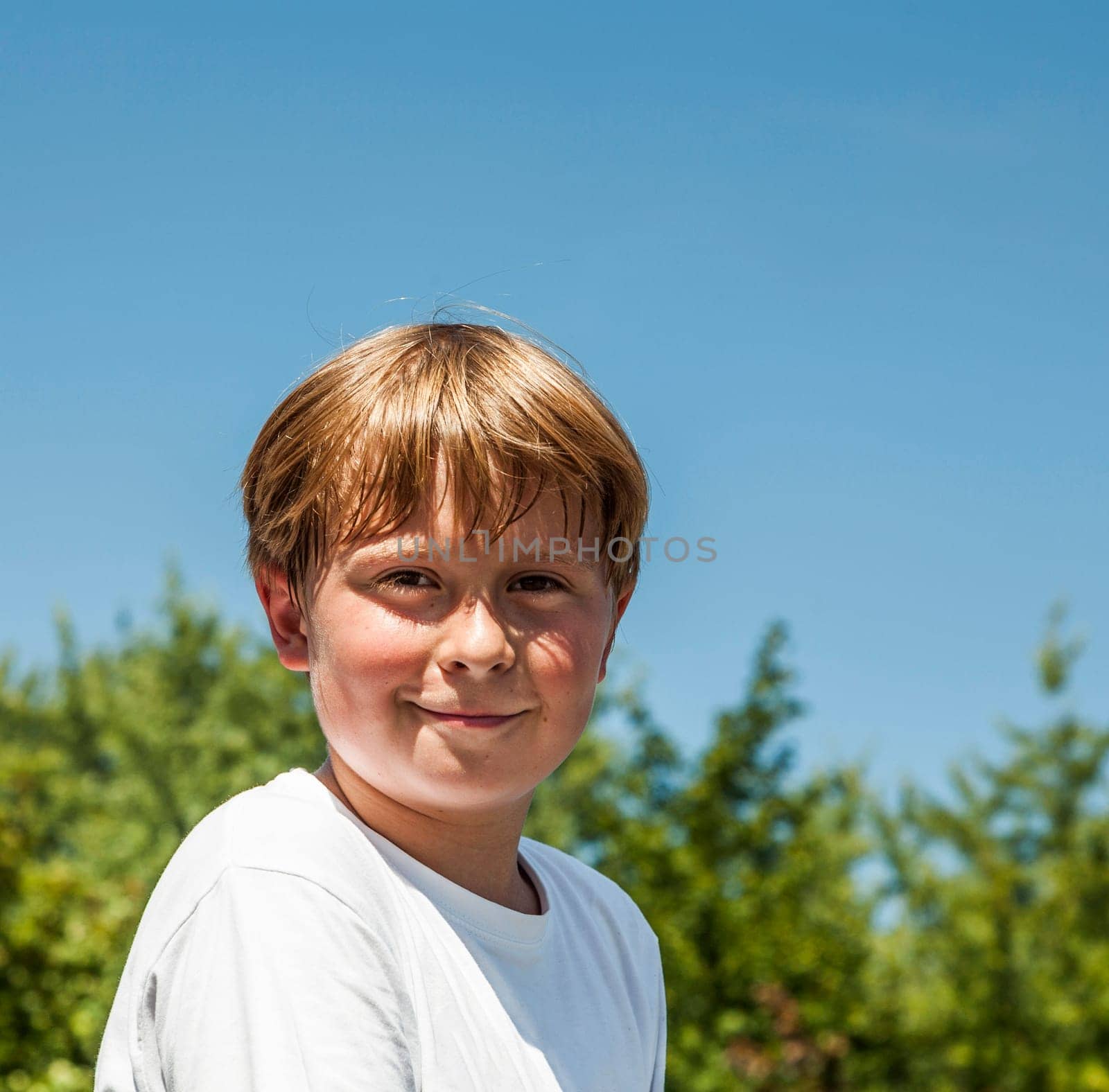 happy boy is smiling and enjoys life under blue sky