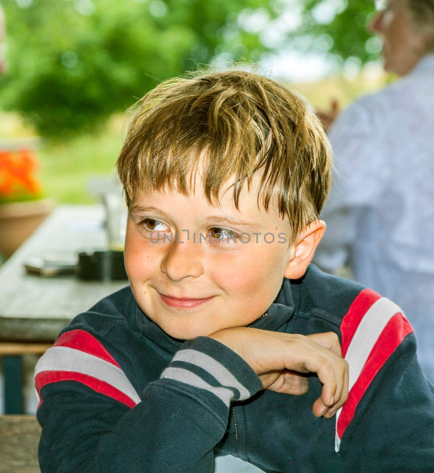 cute boy smiles and has fun sitting at the table